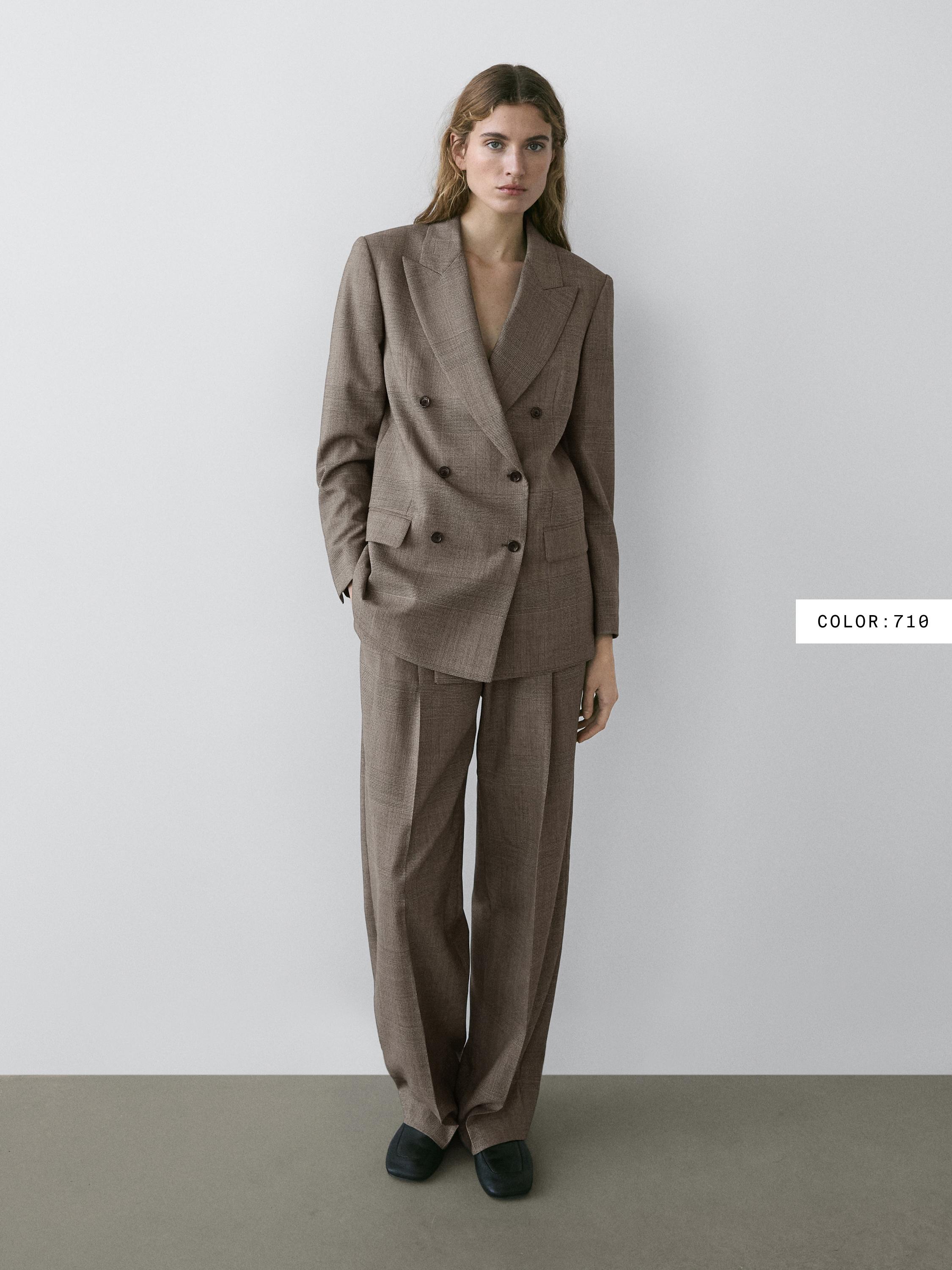 Brown suit set with a double-breasted jacket with flap pockets, straight-leg pants, and black shoes.