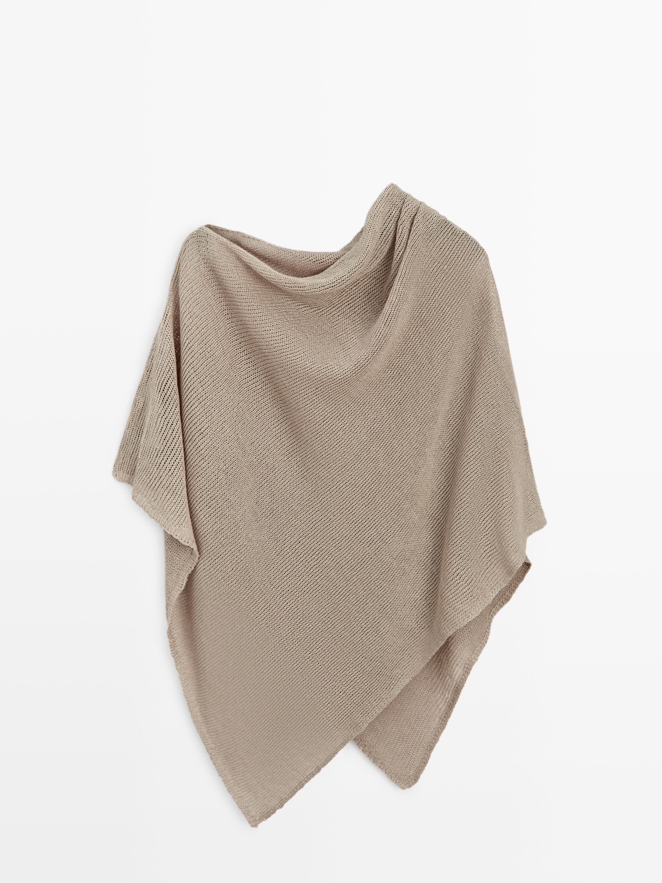 Vista frontal de capa de punto color piedra con diseño asimétrico y textura acanalada.