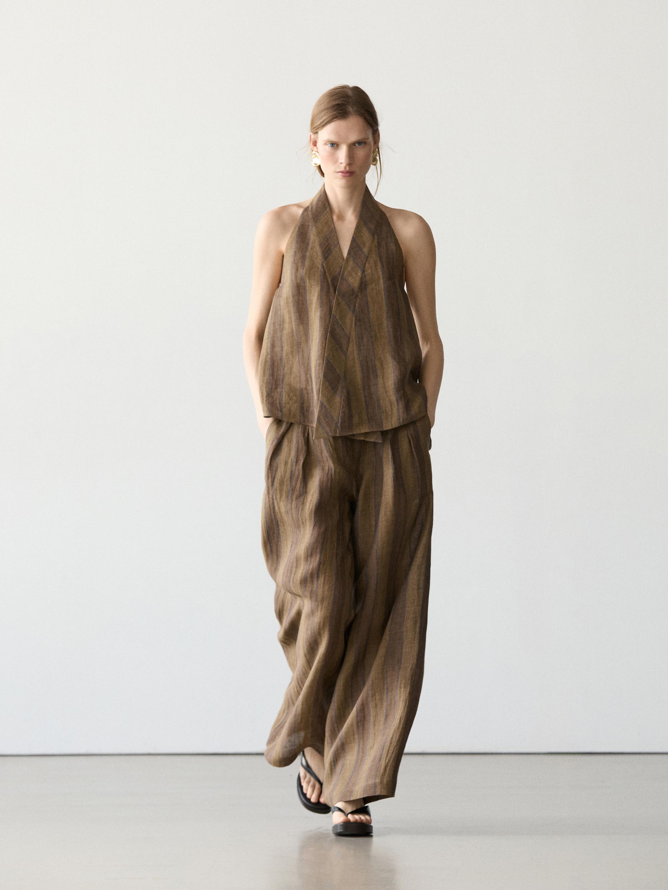 Conjunto de chaleco cruzado y pantalones anchos a rayas en tonos marrones.