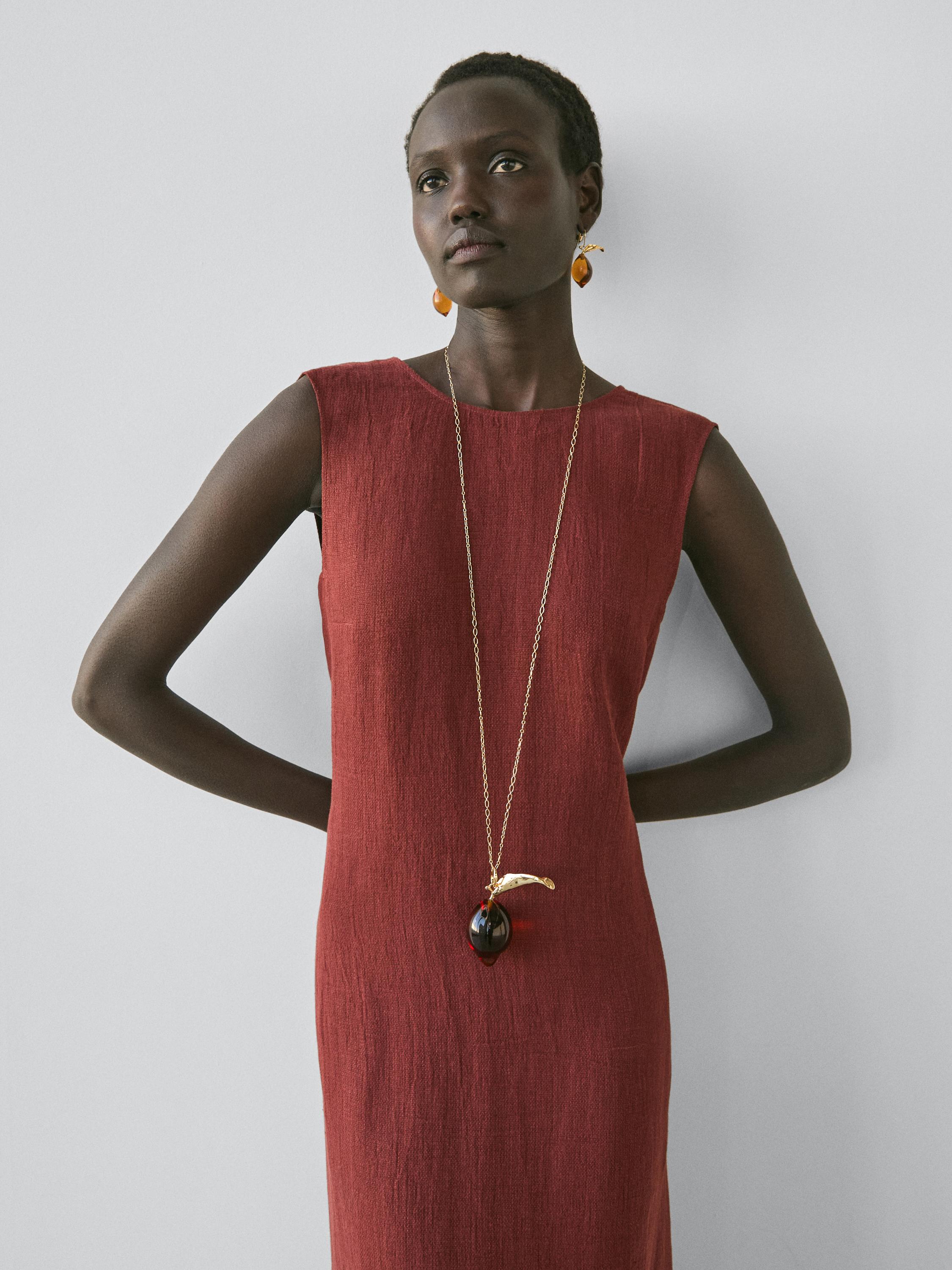 Conjunto de vestido corto color teja sin mangas, cuello redondo, corte recto.