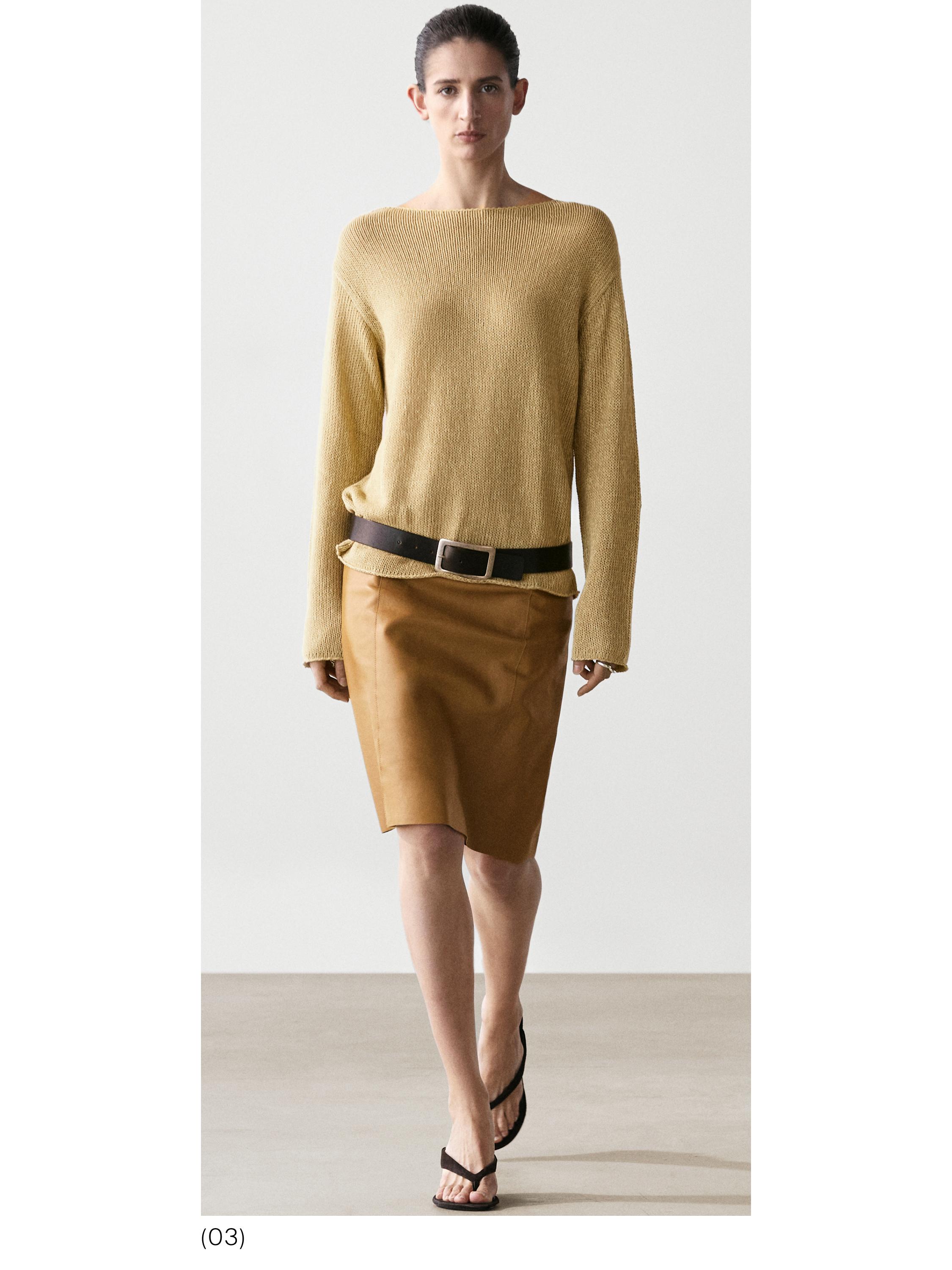 Conjunto de jersey lima de punto calado y falda marrón con cinturón negro.