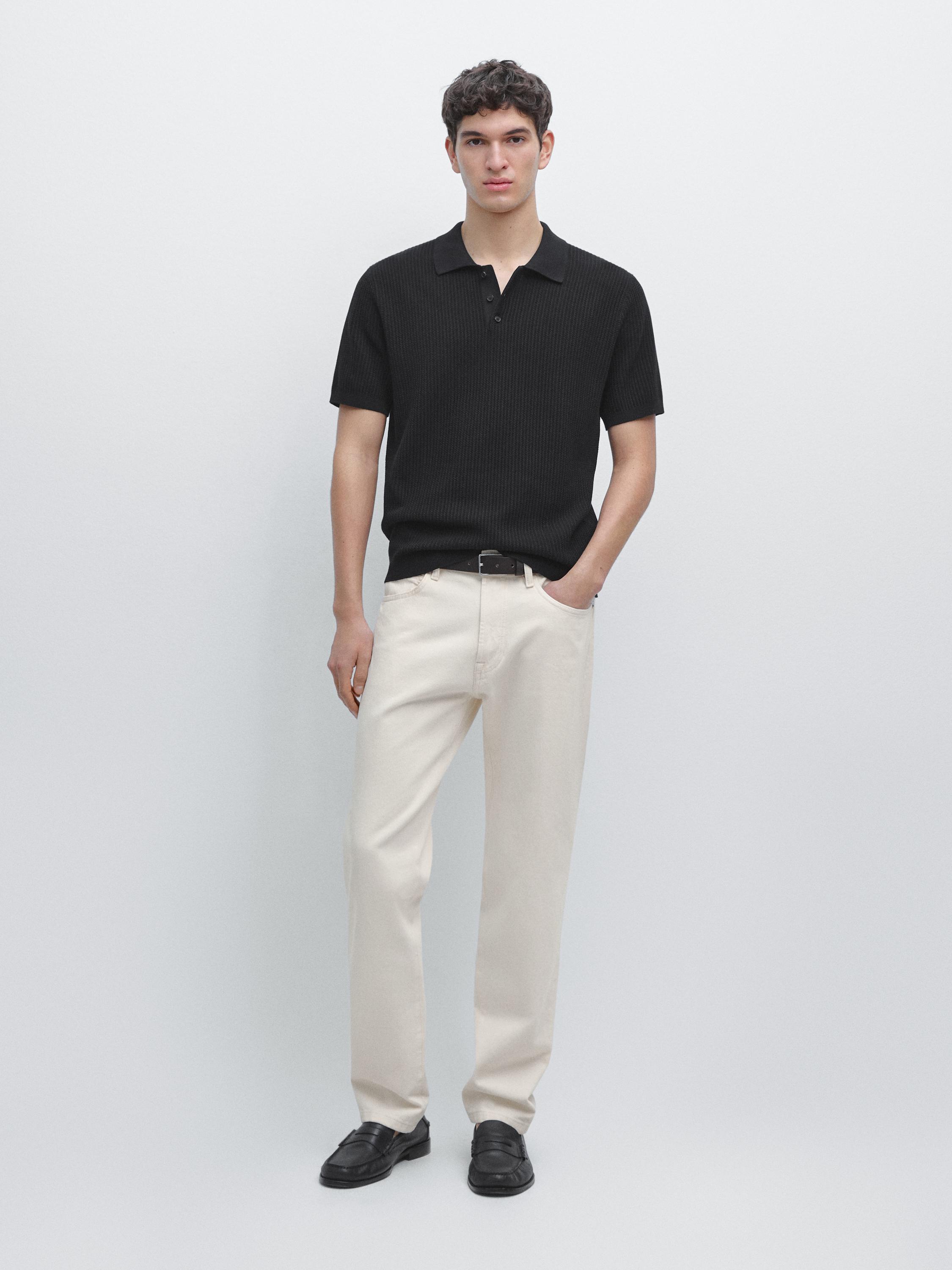 Ensemble polo noir en maille avec manches courtes et pantalon droit beige.