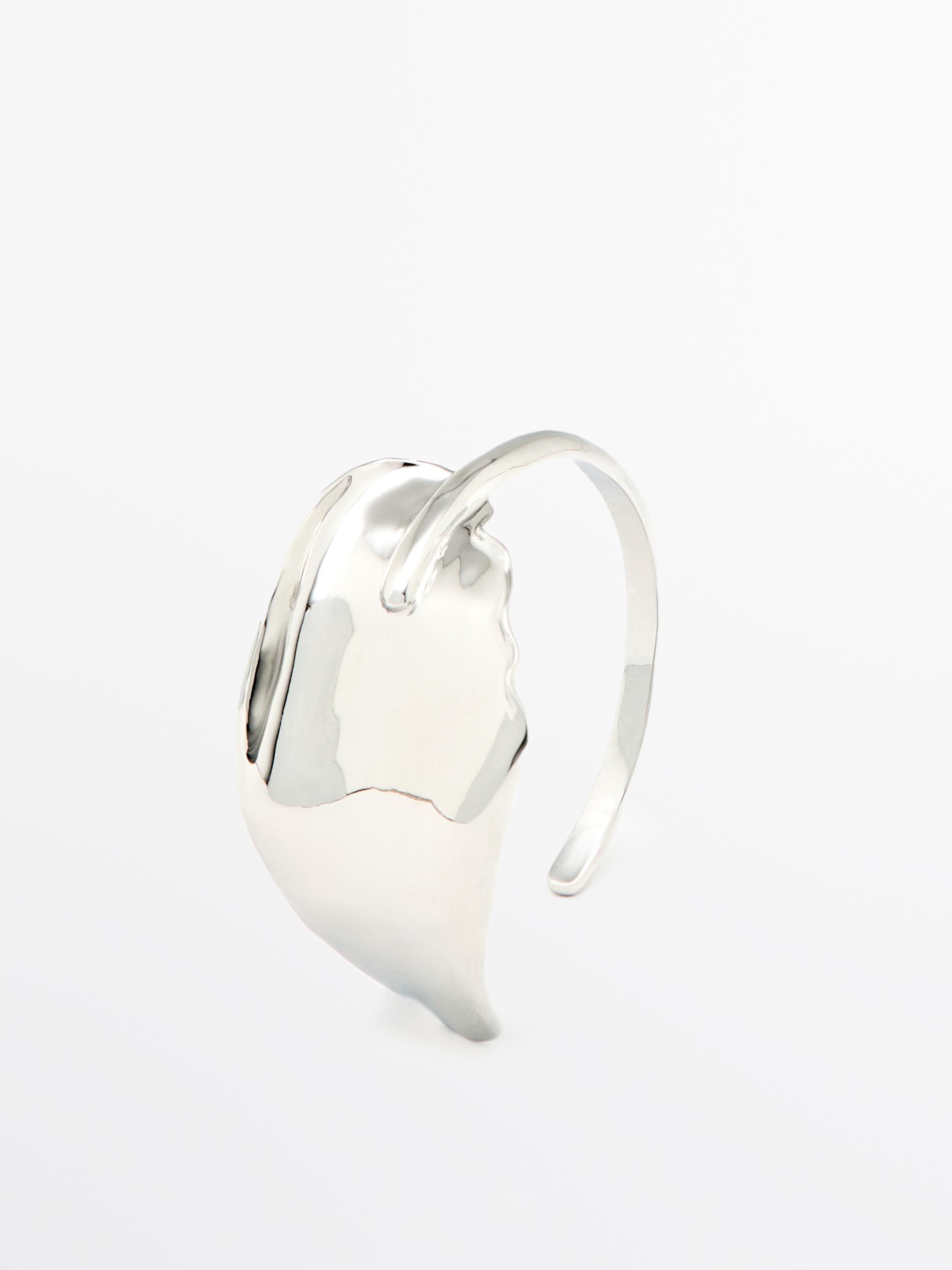 Pulseira larga de prata com textura ondulada e design aberto.