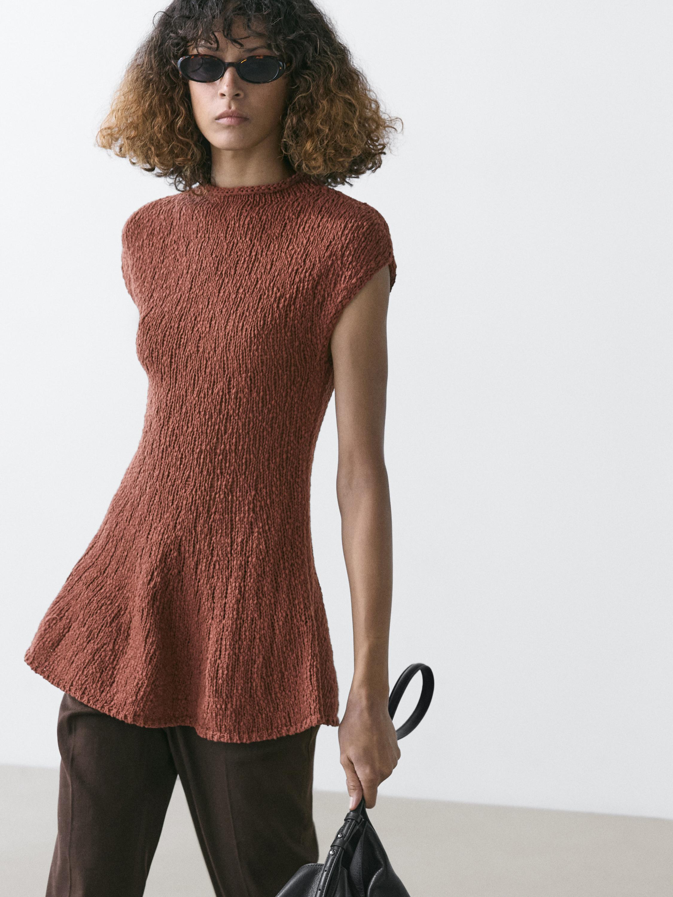 Plano medio de top teja sin mangas con textura, cuello redondo y corte acampanado.