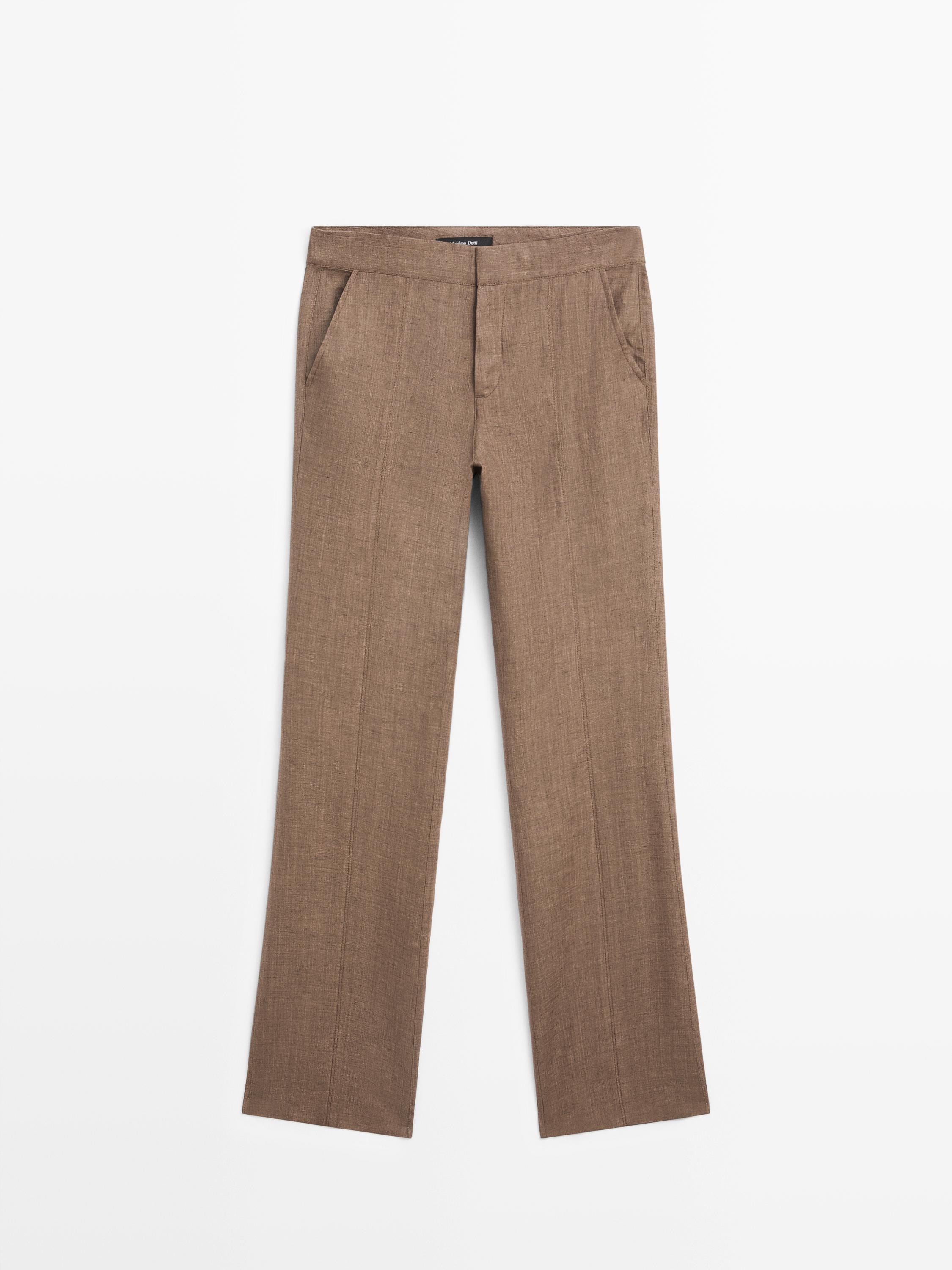 Vista frontal de pantalón marrón kick flare con bolsillos laterales y pliegues frontales.