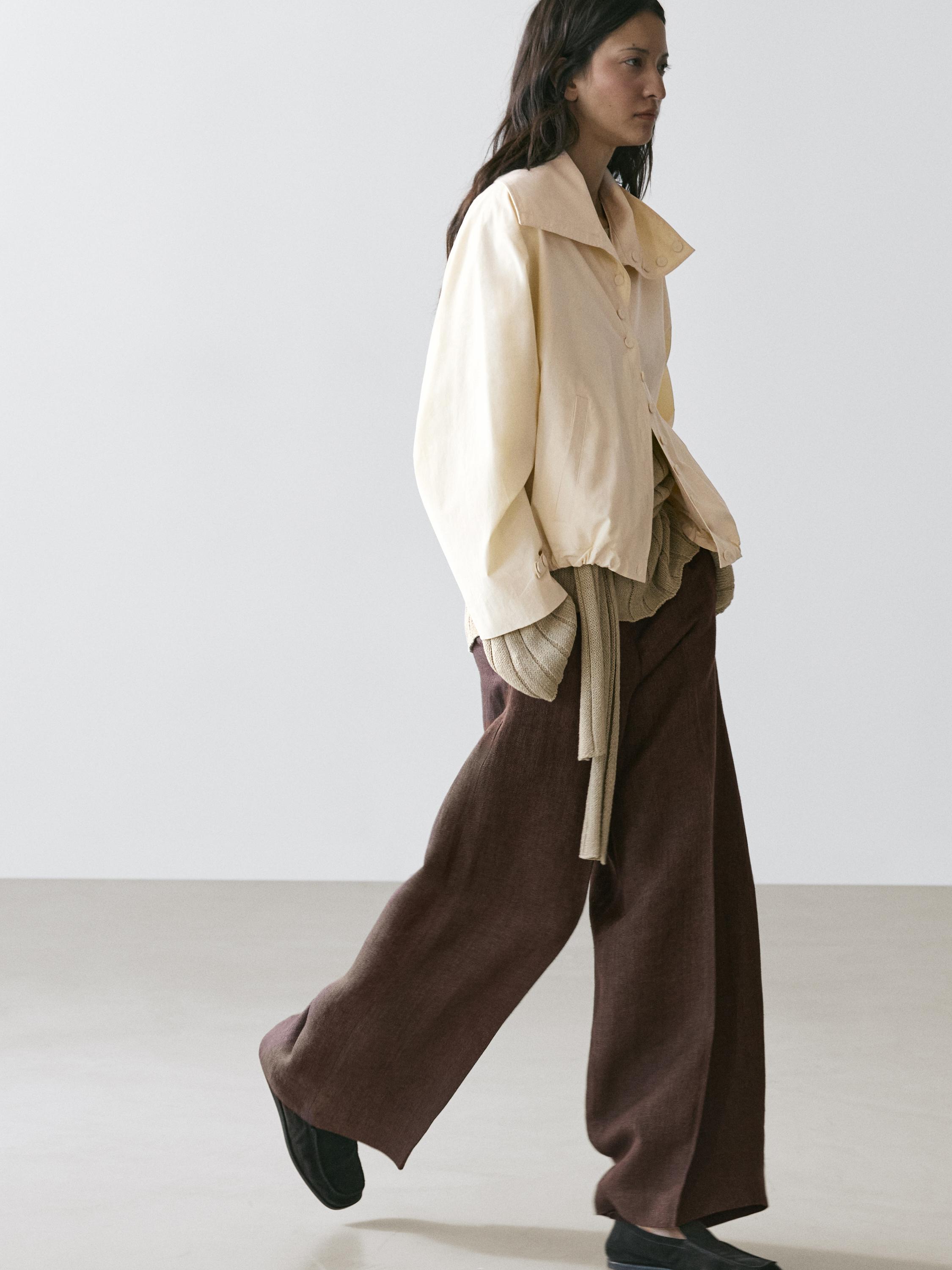 Set aus beigefarbener Jacke mit Knöpfen und weiter brauner Hose.