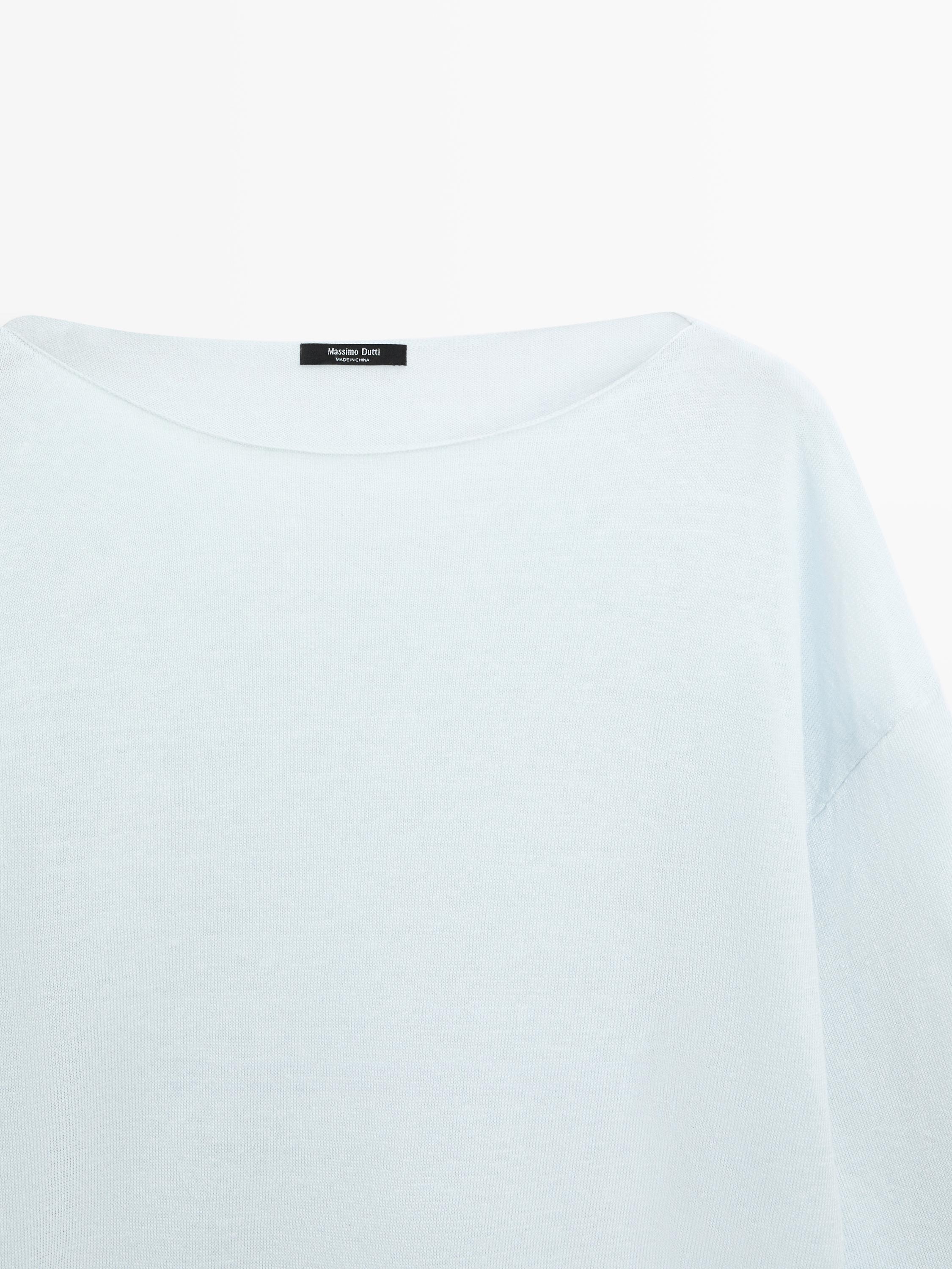 Primer plano de cuello barco de jersey azul celeste.