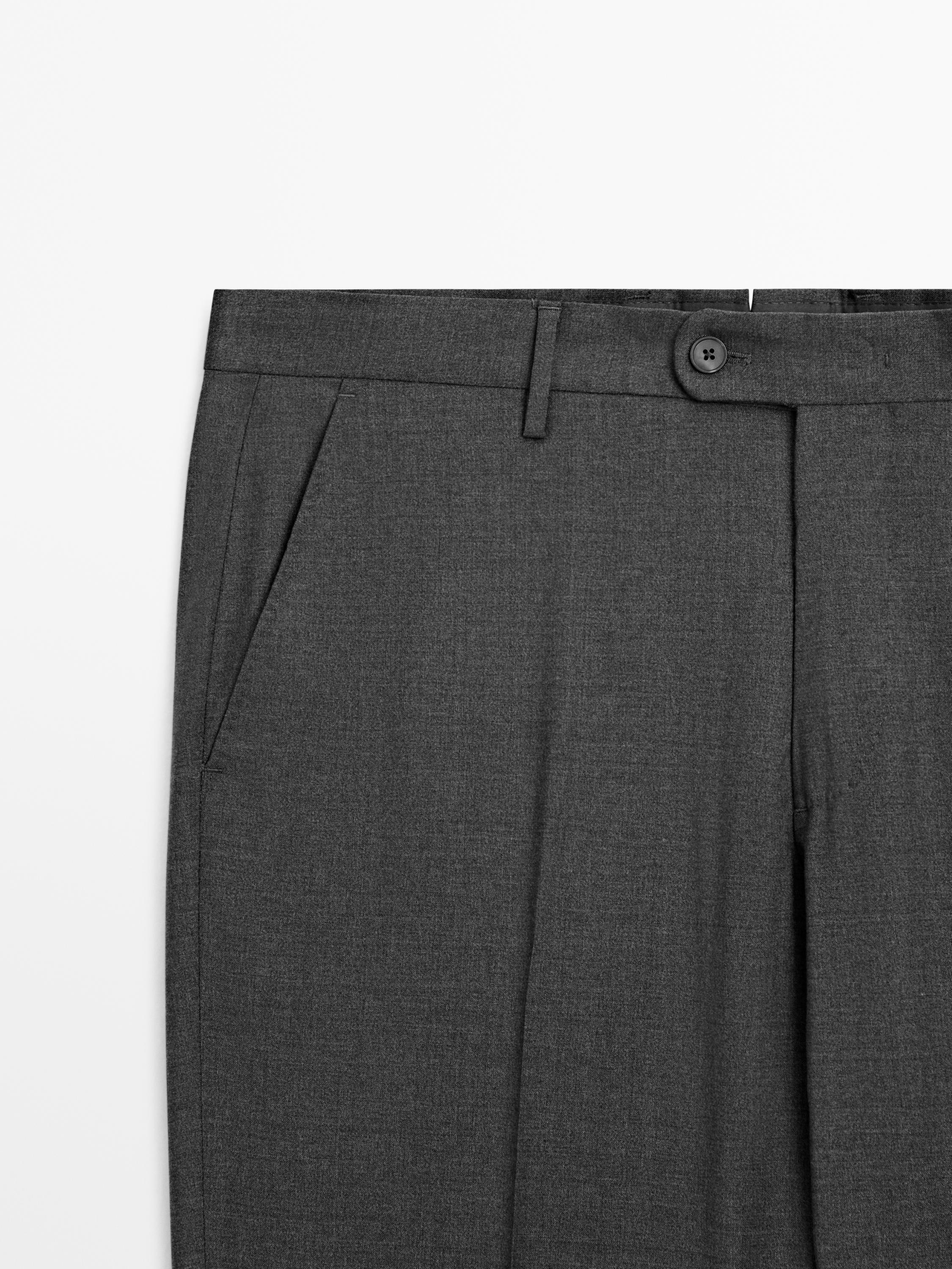 Mid-shot of gray pants with side pockets and visible button closure.
