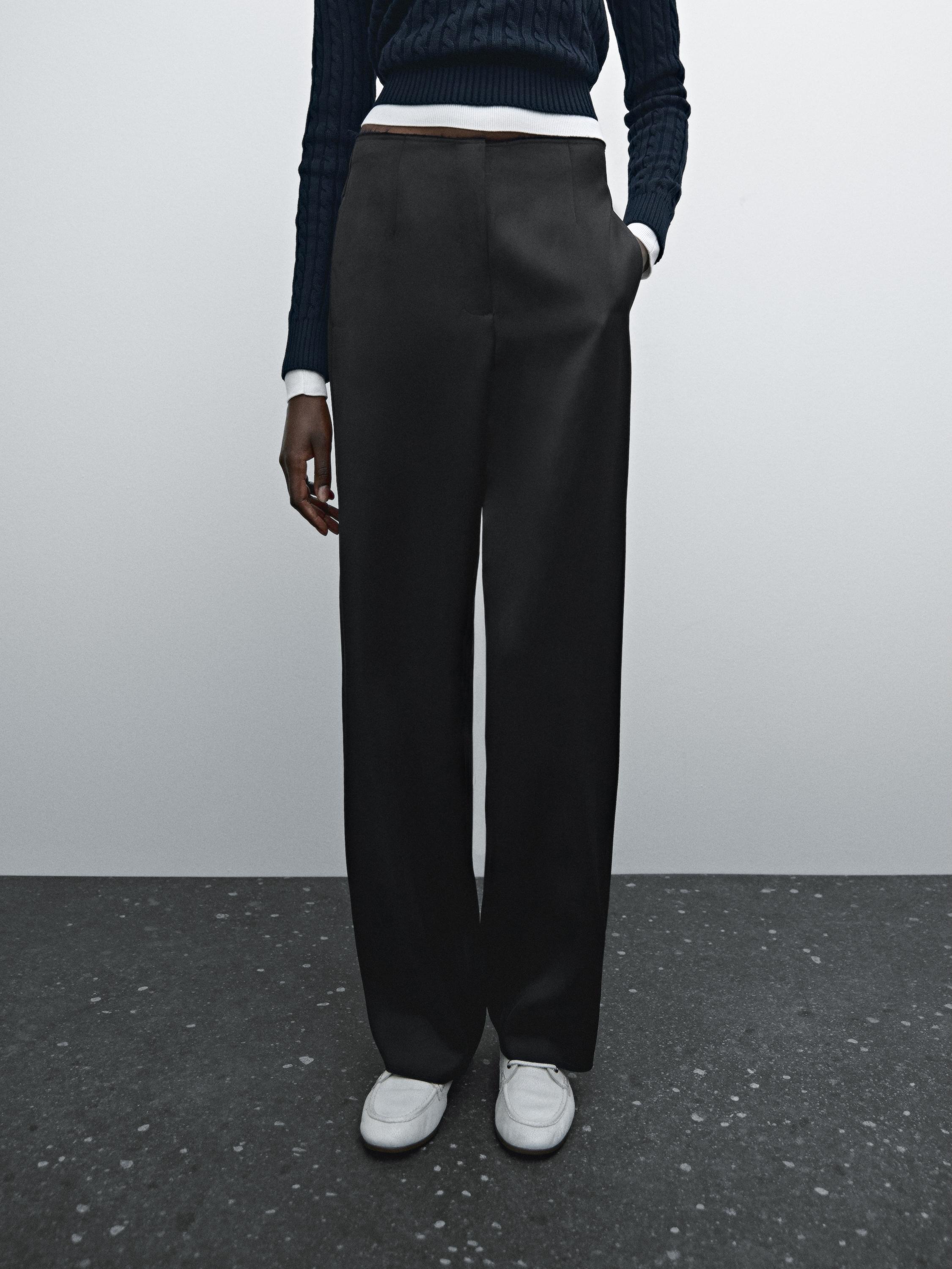 Ensemble pantalon noir à jambes larges et pull texturé bleu marine, poches latérales apparentes.