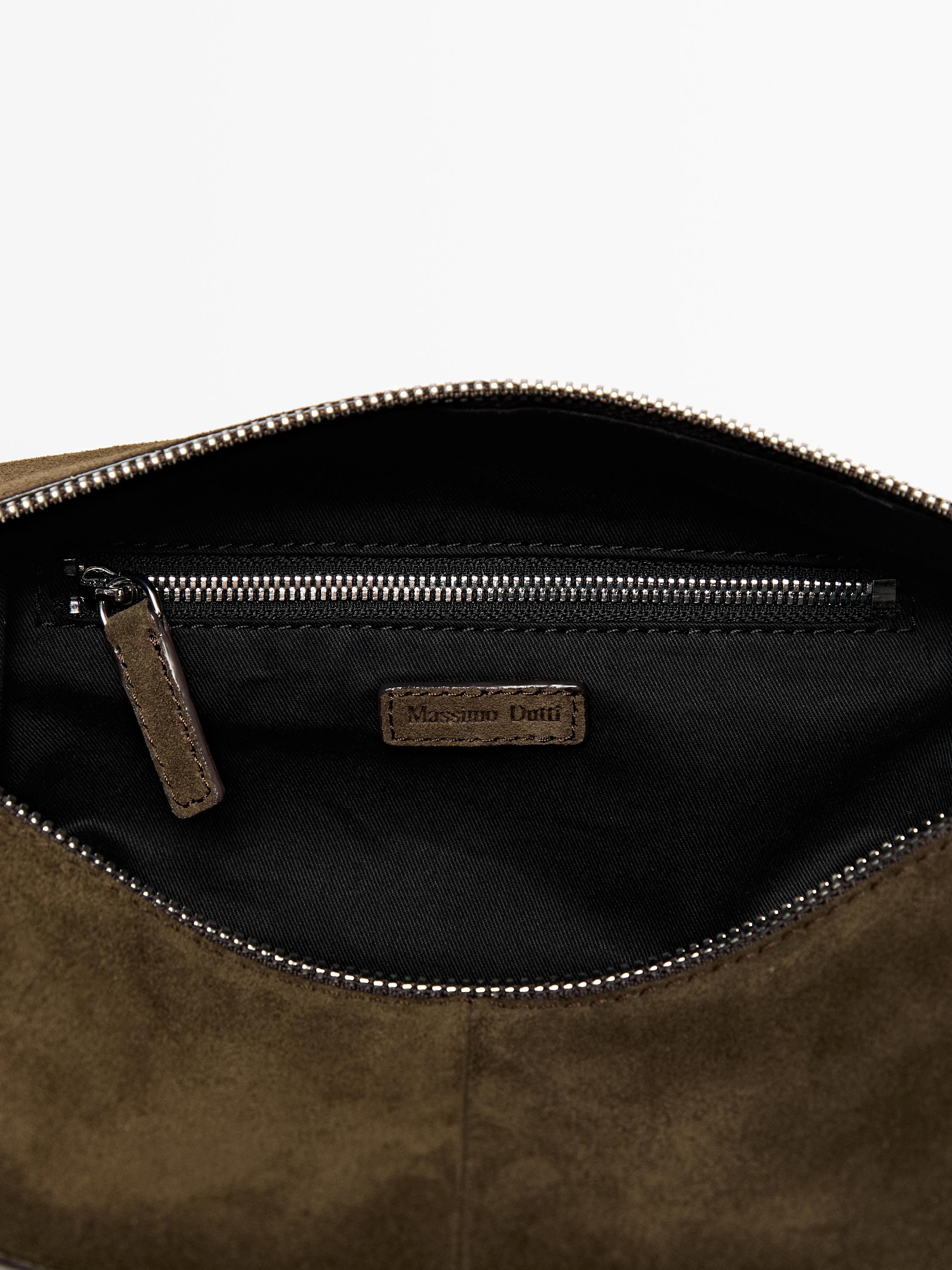 Деталь несессера цвета хаки с открытой молнией, внутренним карманом на молнии и этикеткой с надписью "Massimo Dutti".
