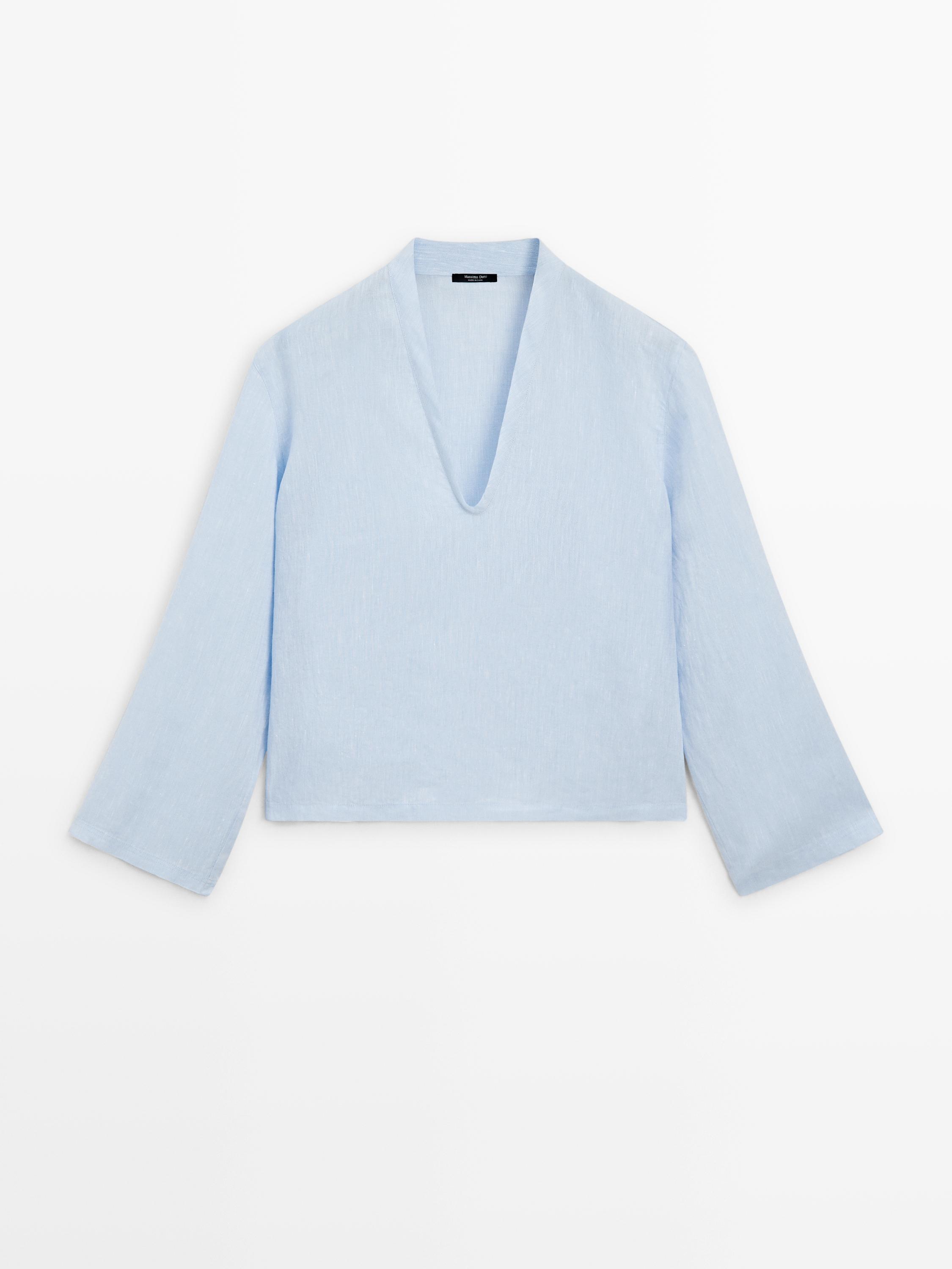Vista frontal de camisa celeste con cuello en V y mangas largas.