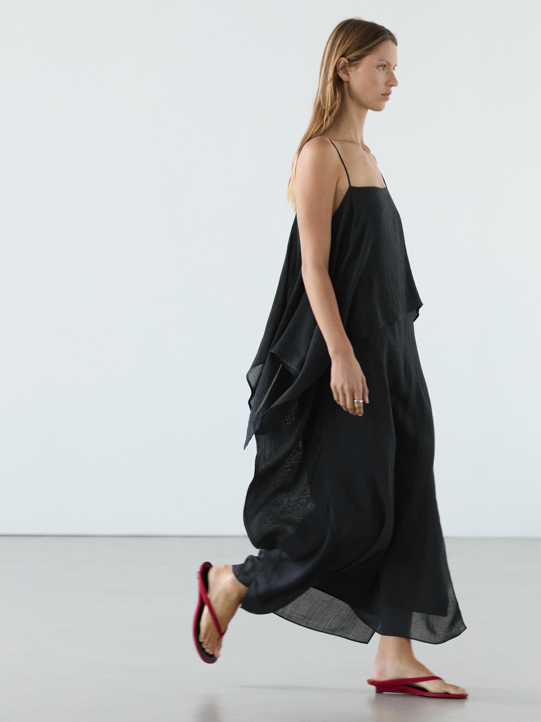 Conxunto de vestido midi azul escuro con tirantes finos e volante asimétrico, combinado con sandalias vermellas.