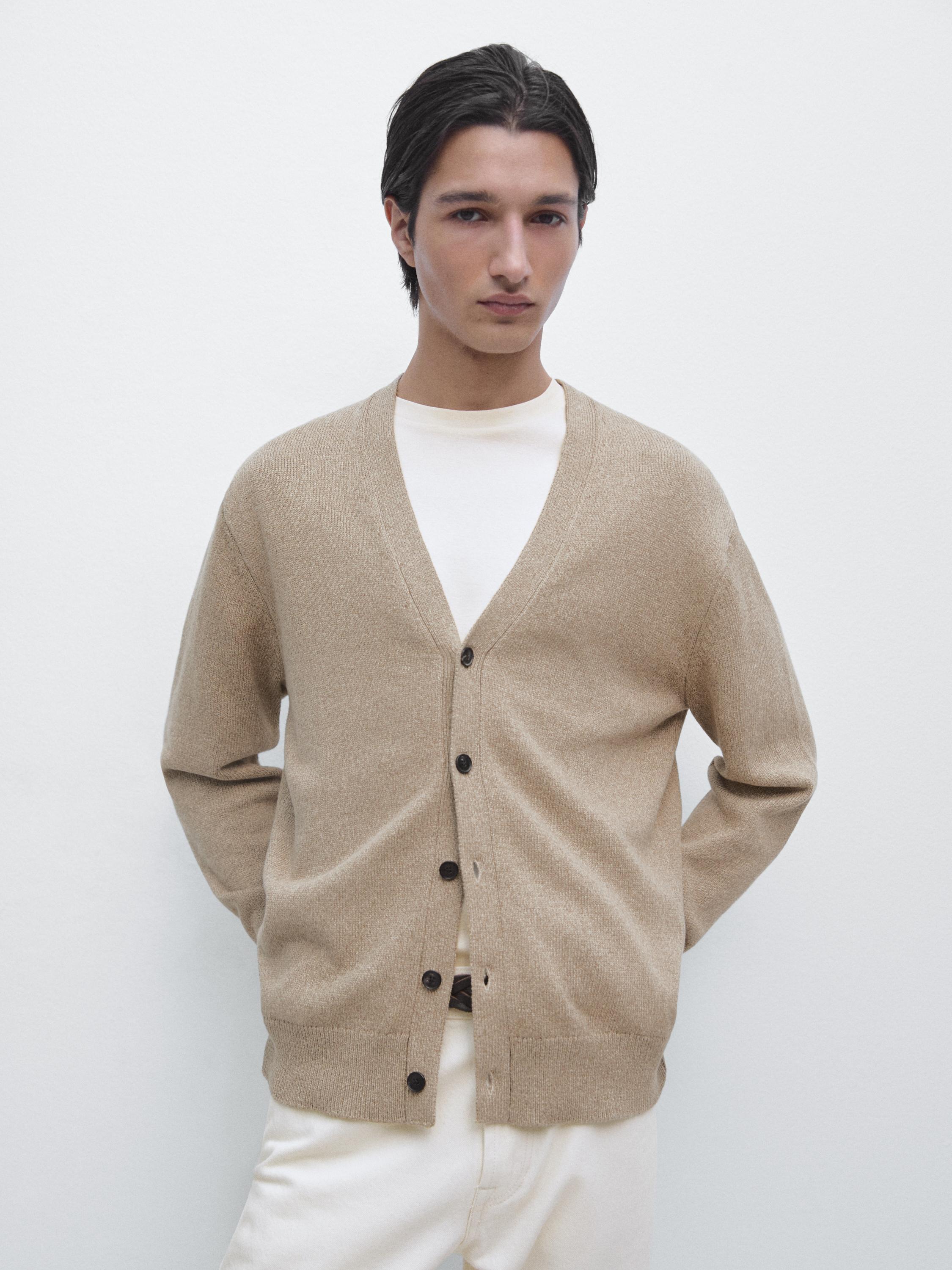 Conjunto de cárdigan verdoso con botones oscuros y camiseta blanca.