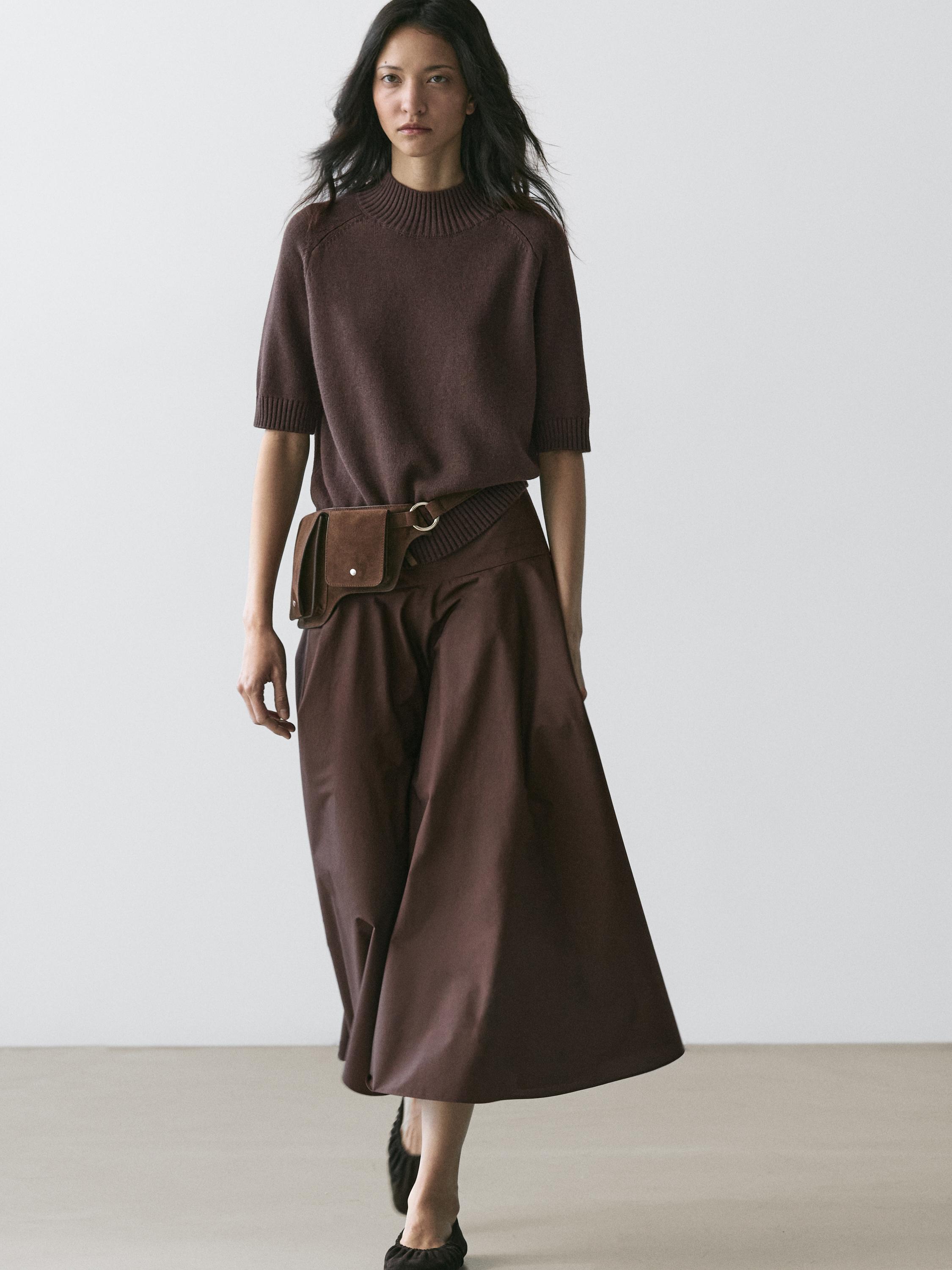 Ensemble pull marron à manches courtes et culottes marron avec ceinture et sac frontal.