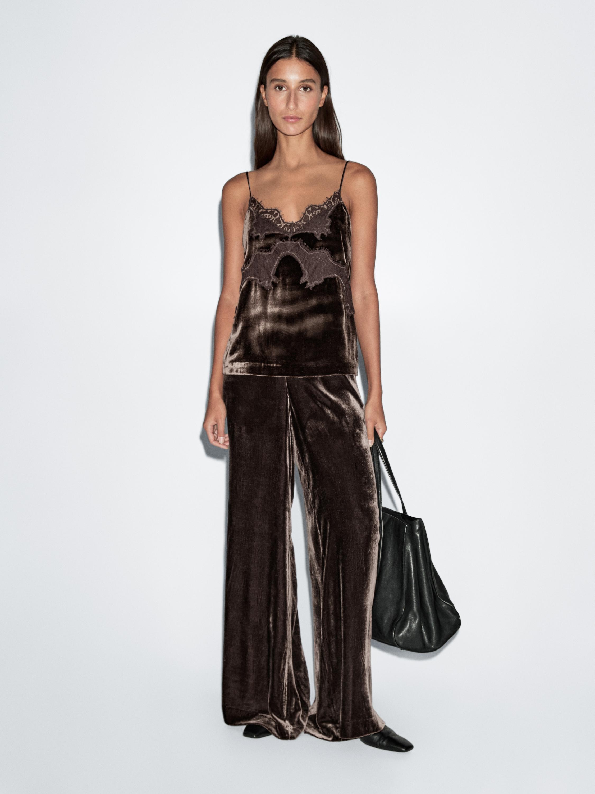 Ensemble comprenant un top marron à fines bretelles et dentelle au décolleté, un pantalon marron ample et un sac noir.