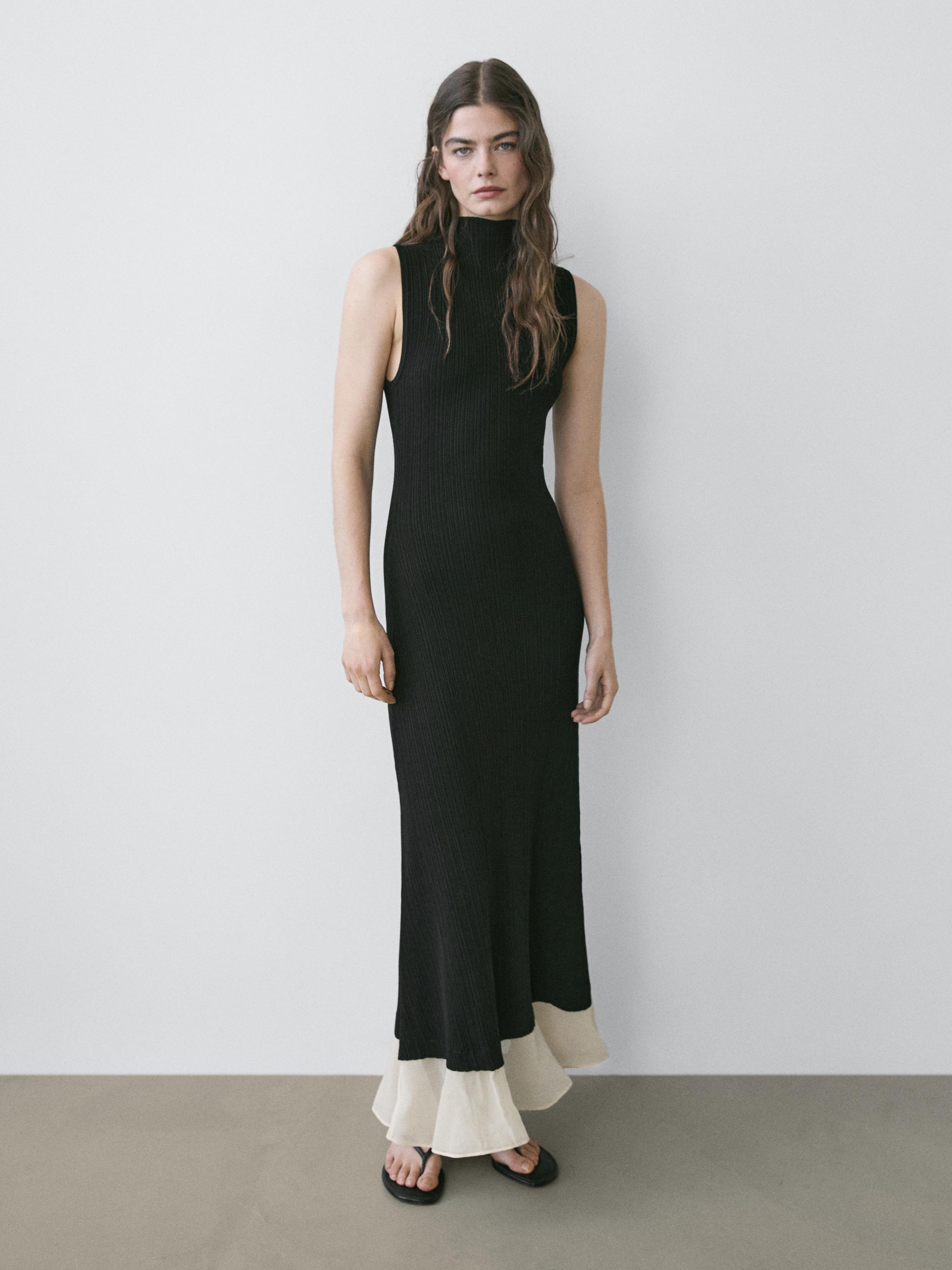 Μαύρο αμάνικο midi φόρεμα με ψηλό λαιμό και βολάν σε αντίθεση λευκού στο τελείωμα.