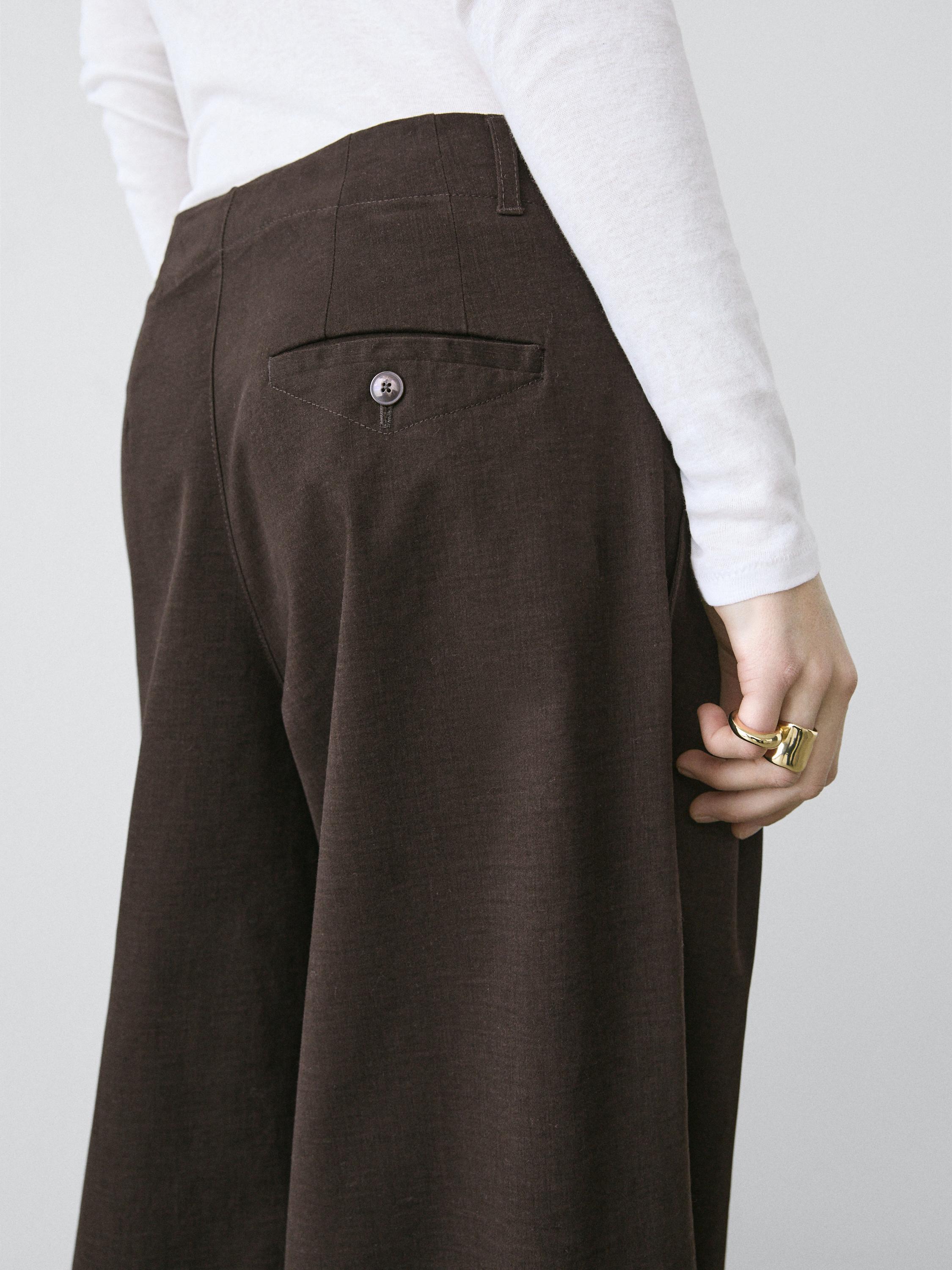 ყავისფერი შარვლის საშუალო ხედი უკანა ჯიბით და ღილაკით.