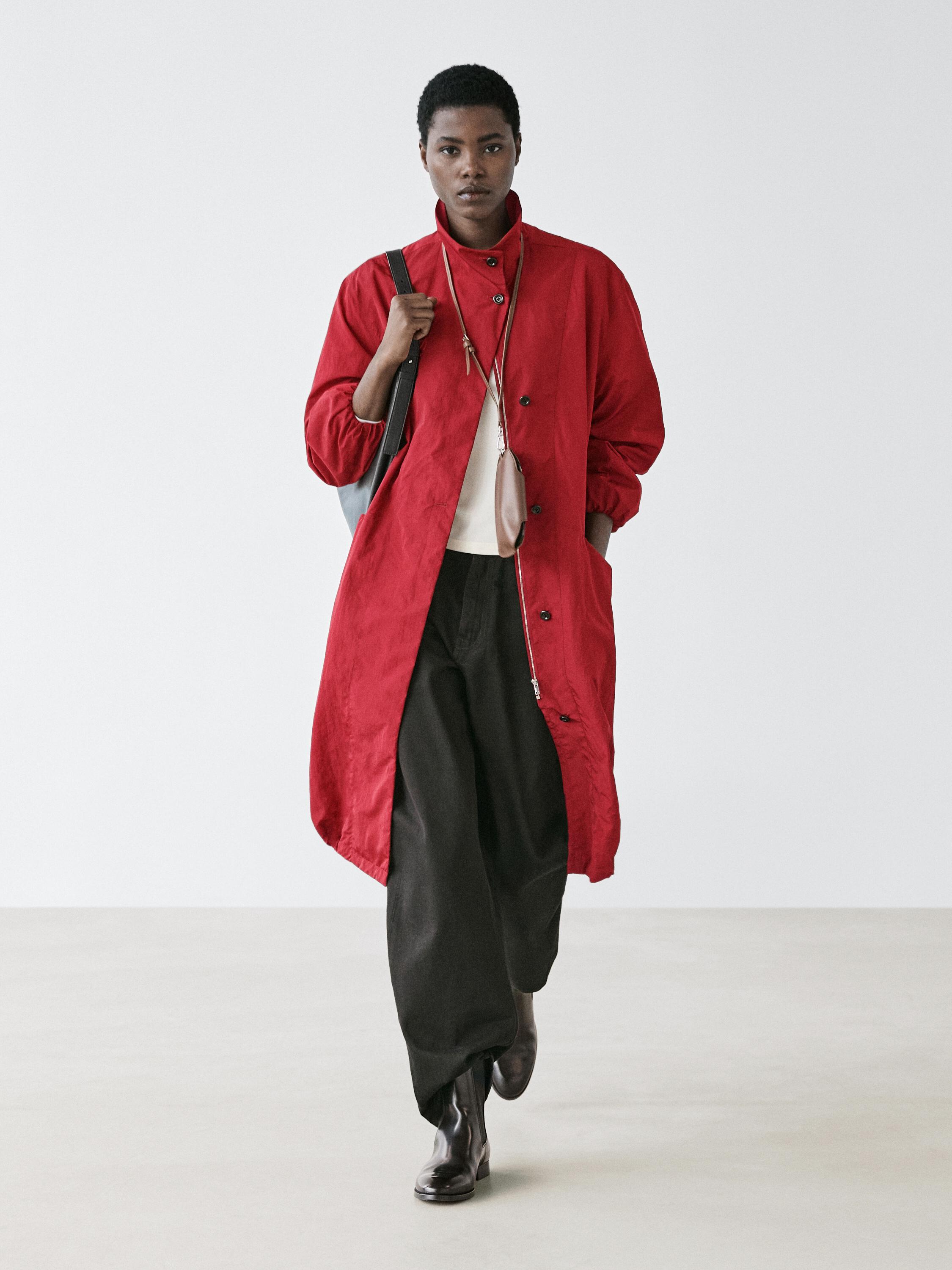Red long parka set with buttons, black wide-leg pants, and dark boots.