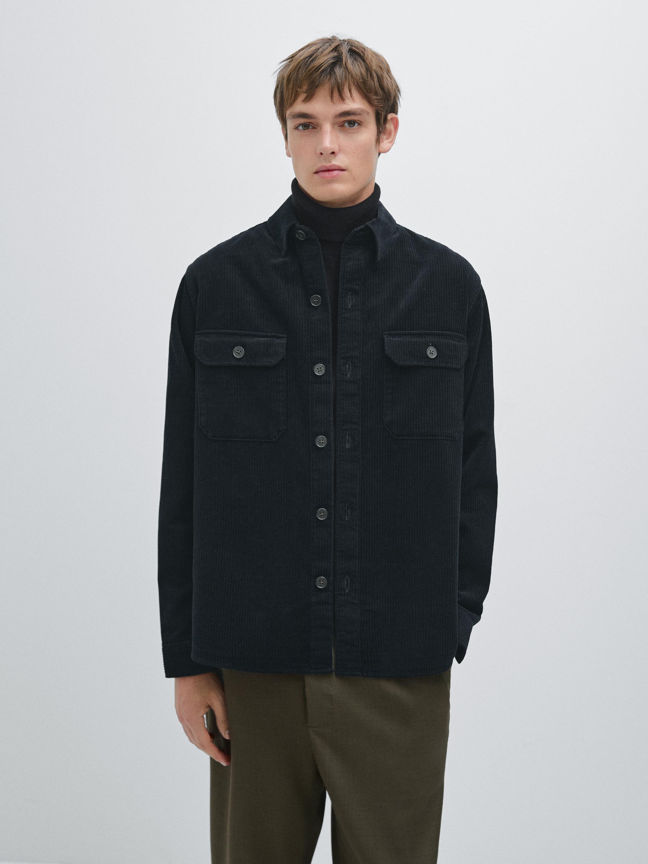 Conjunt de sobrecamisa verda amb butxaques frontals amb solapa i pantalons marrons.