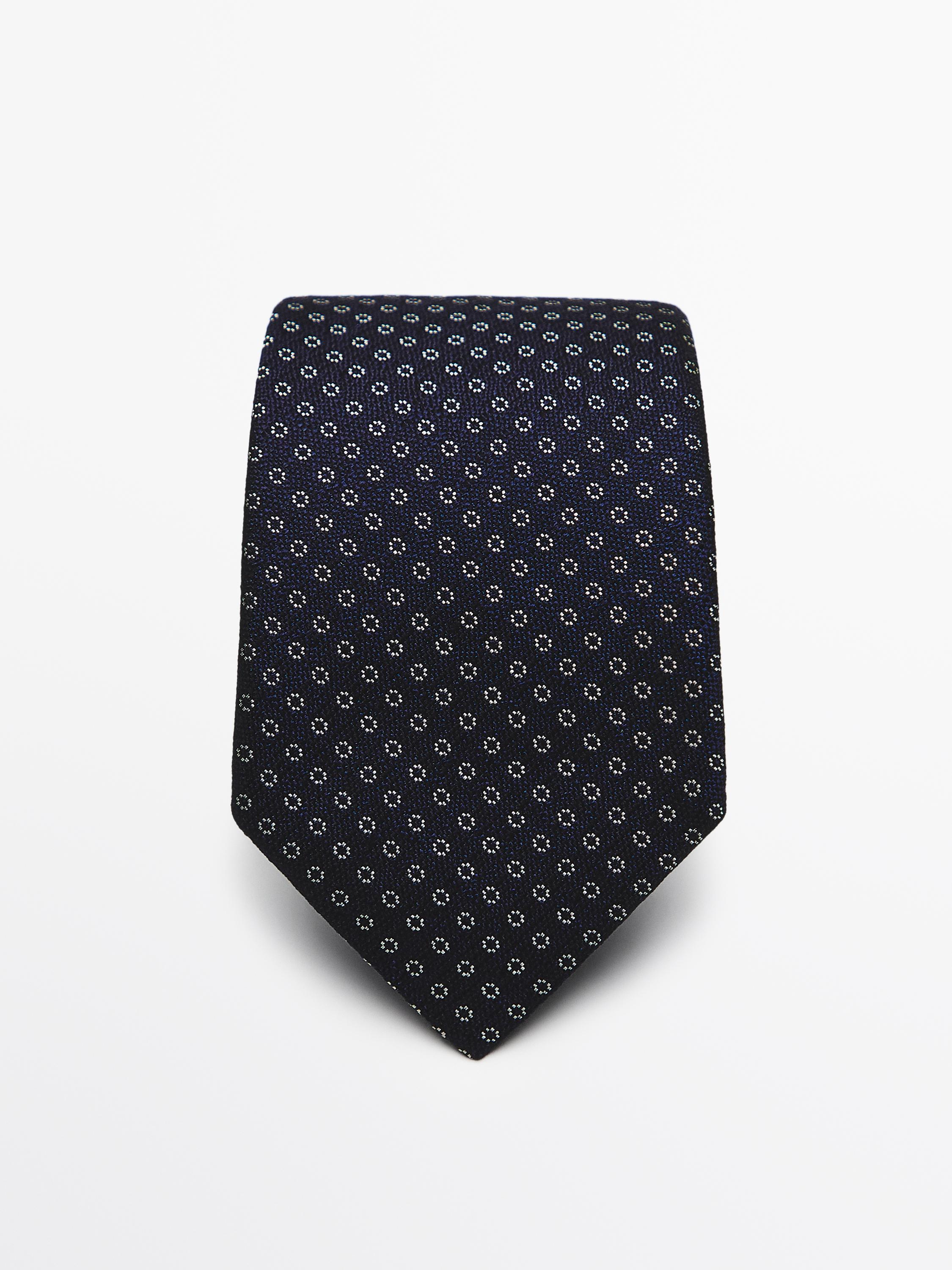 منظر أمامي لربطة عنق كحليّة مطبوعة بنقشة دوائر بيضاء صغيرة.