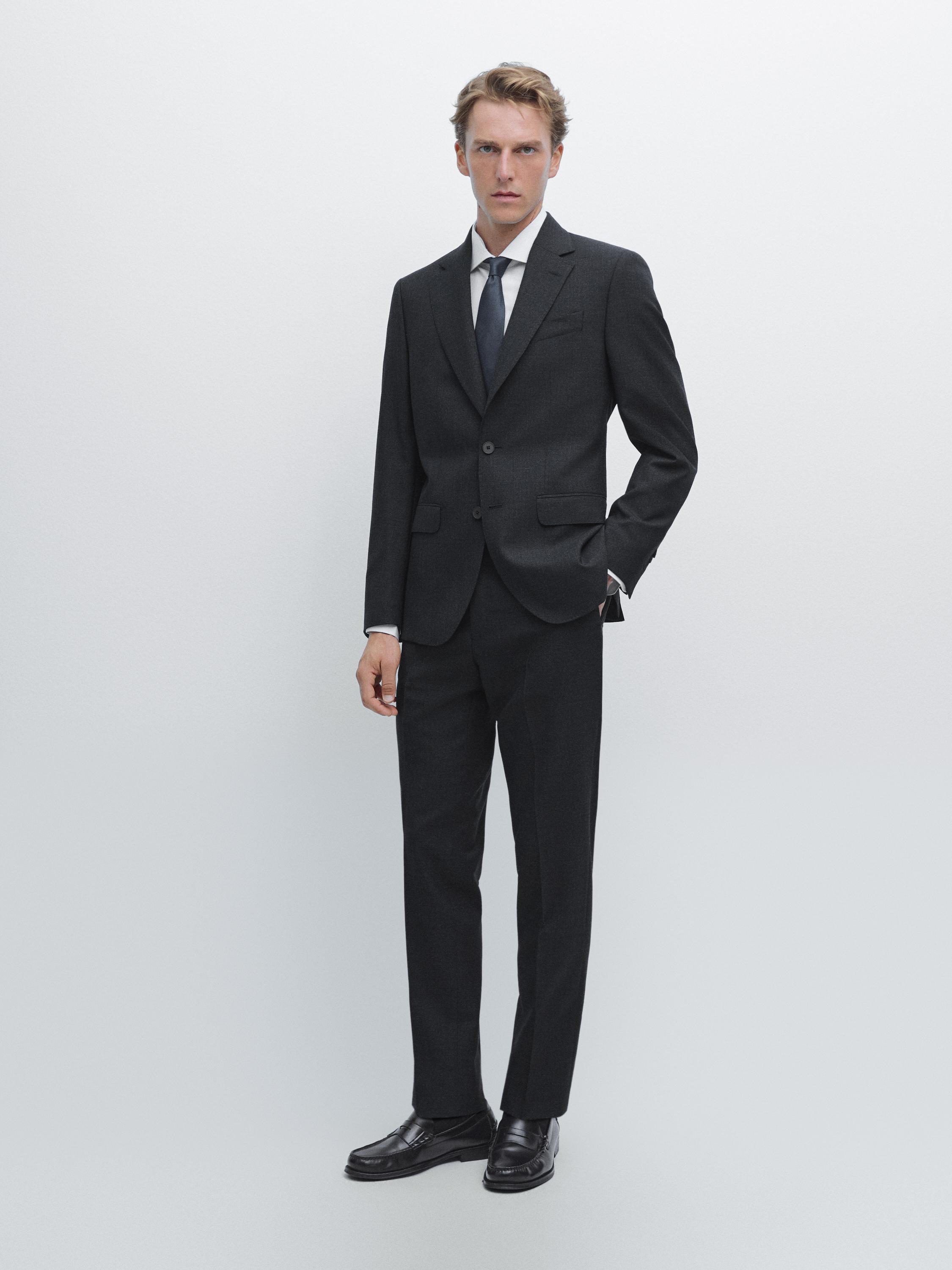 Ensemble de costume bleu marine avec veste à deux boutons, poches à rabat et pantalon droit.