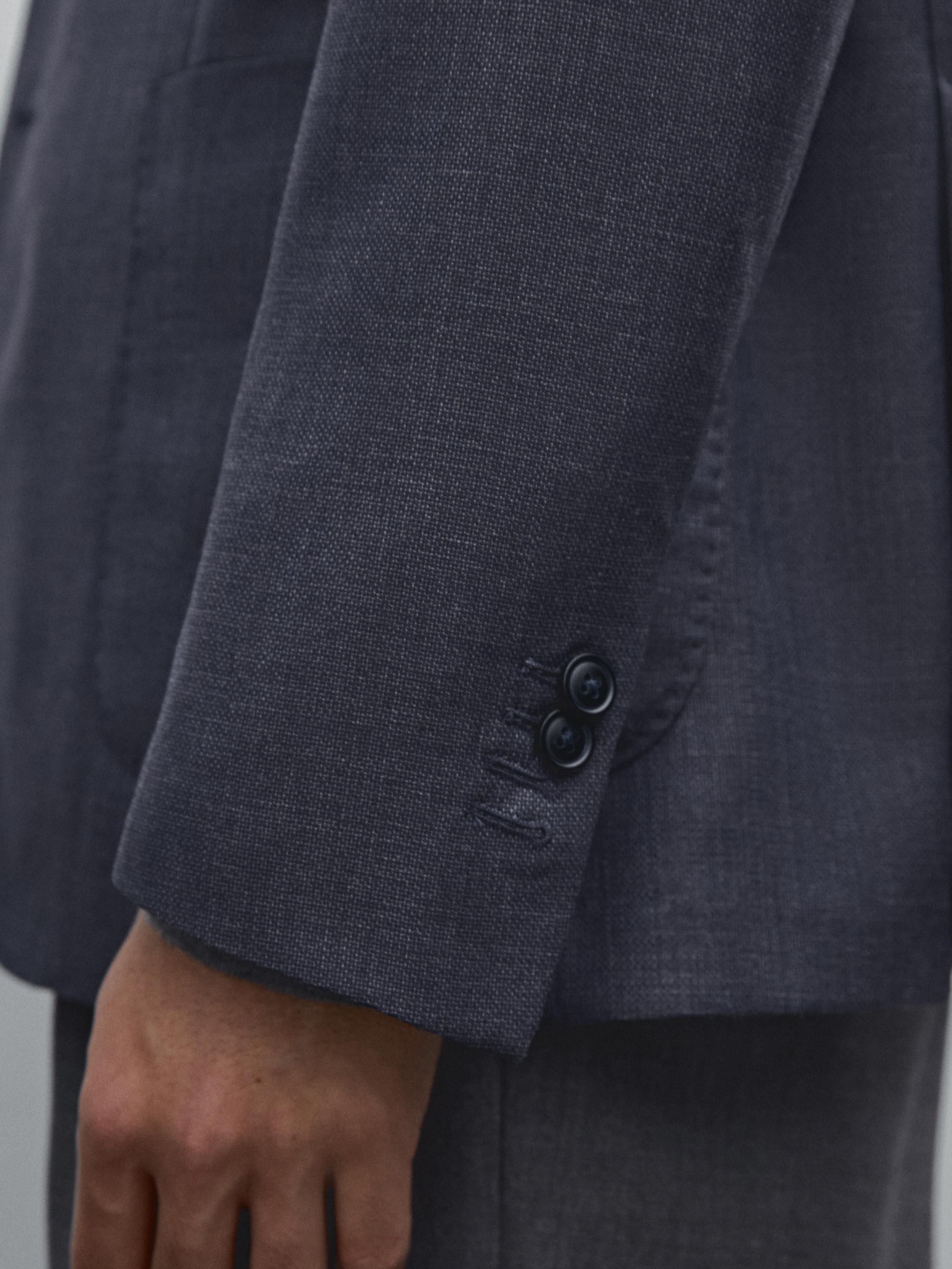 تفاصيل كمّ سترة رمادية بأزرار سوداء.