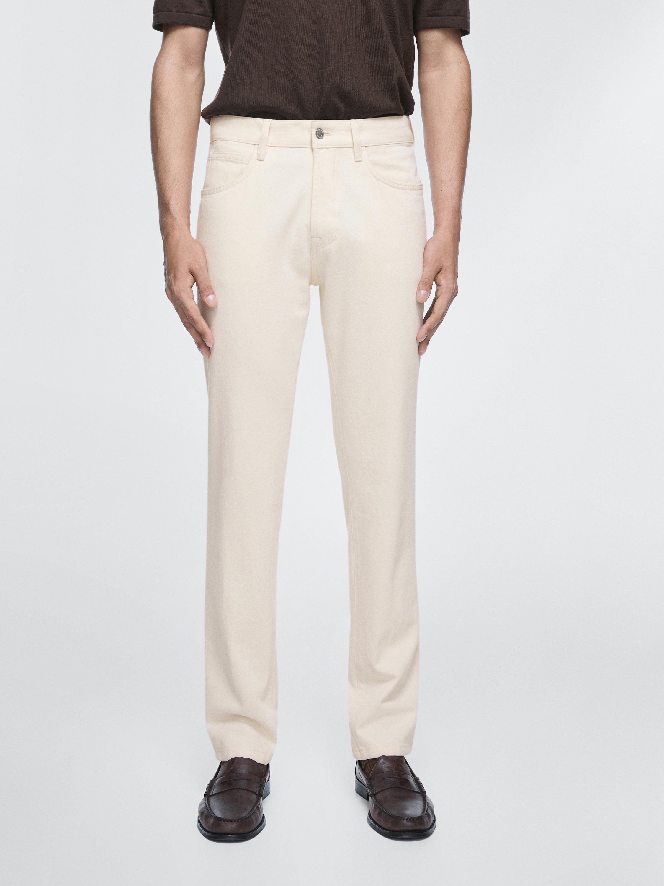 Conjunto de jeans crudos tapered fit con bolsillos delanteros y traseros, botón y cremallera frontal.