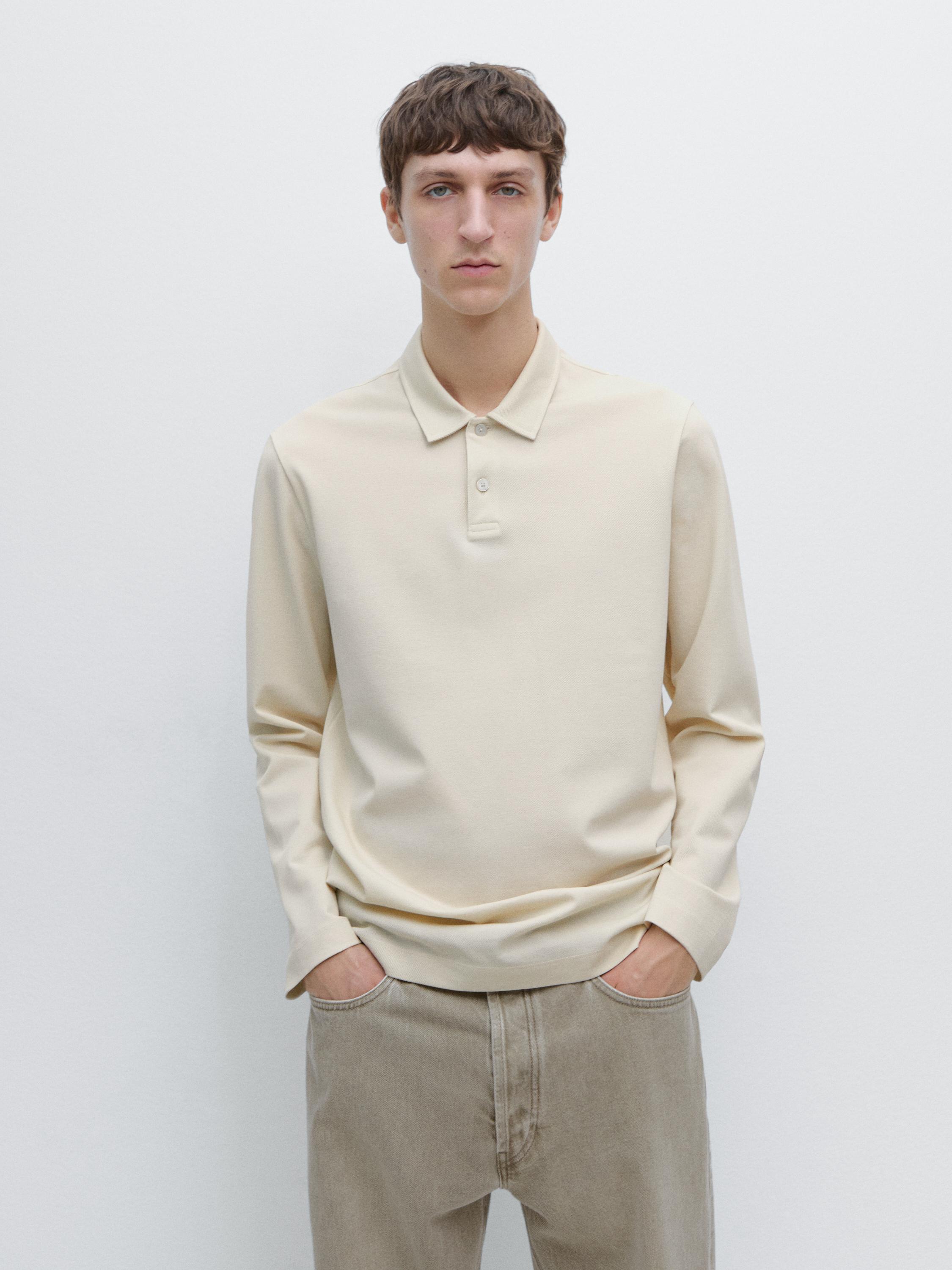 Ensemble polo blanc cassé à manches longues avec col classique et pantalon beige.