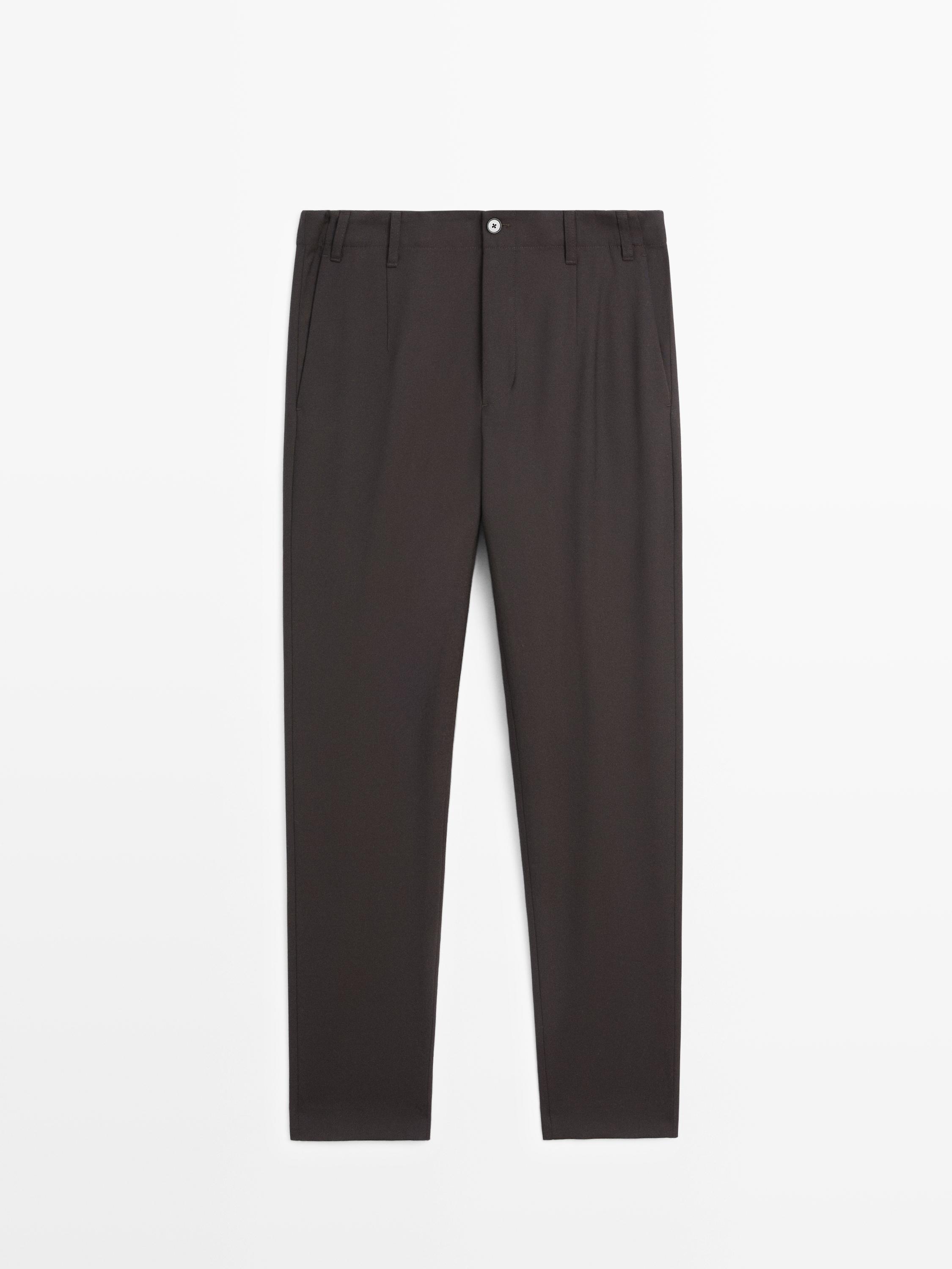 Pogled spreda na braon pantalone sa bočnim džepovima i kopčanjem na dugme.