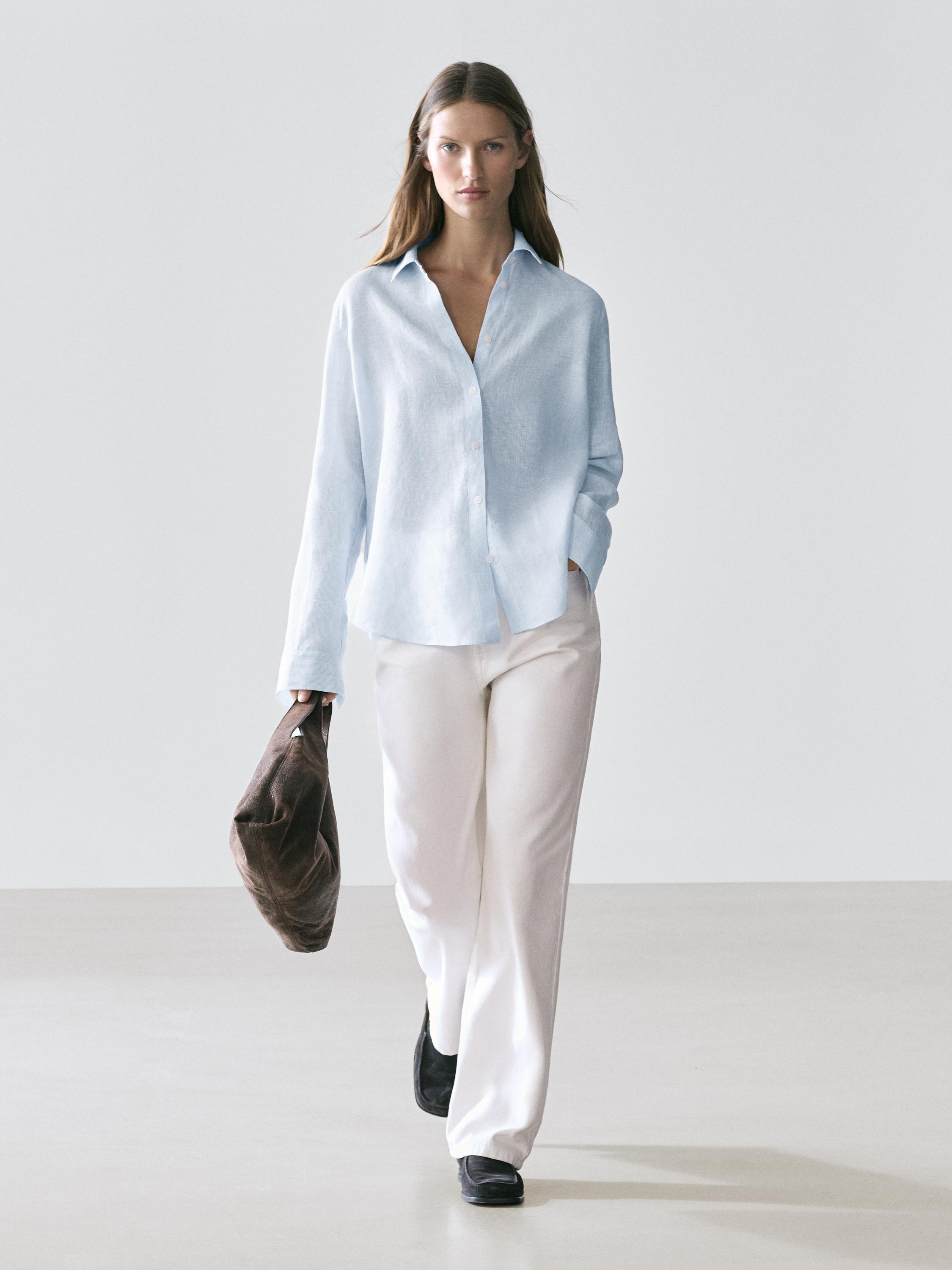 Conjunto de camisa celeste fluida con botones y pantalones blancos rectos.