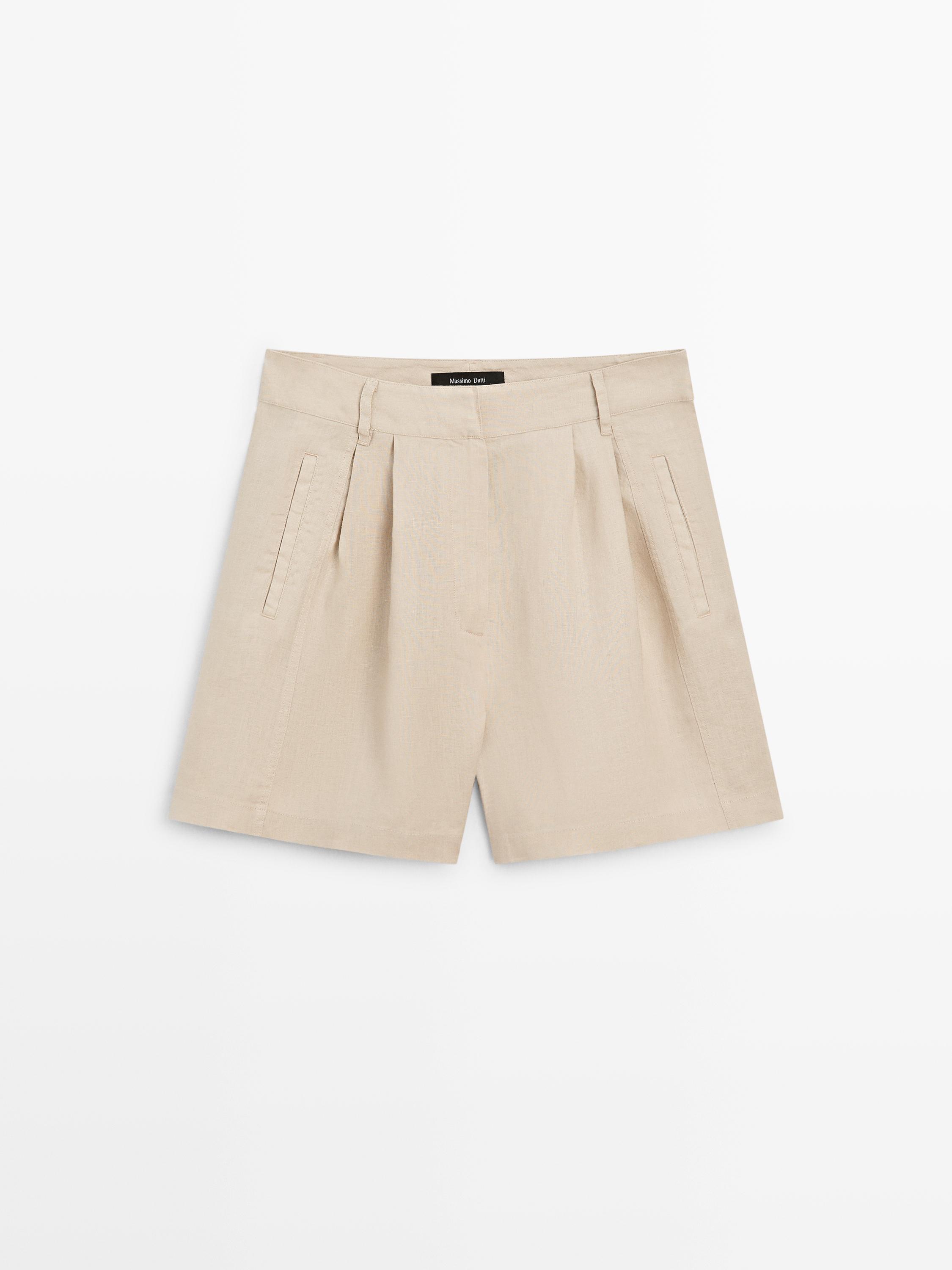 ภาพด้านหน้าของกางเกงเบอร์มิวดาสีทราย มีจีบและกระเป๋าข้าง