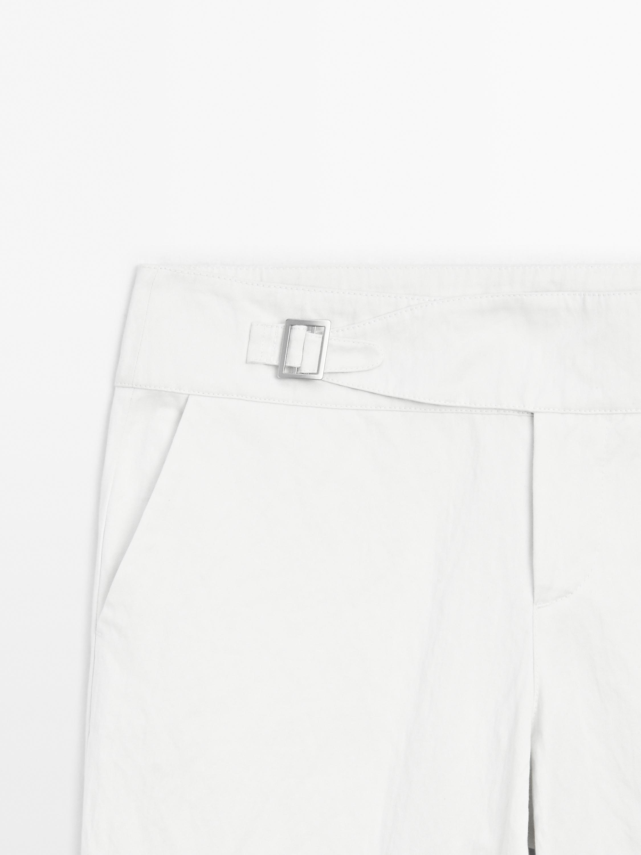 Slim fit low-rise trousers with buckles
