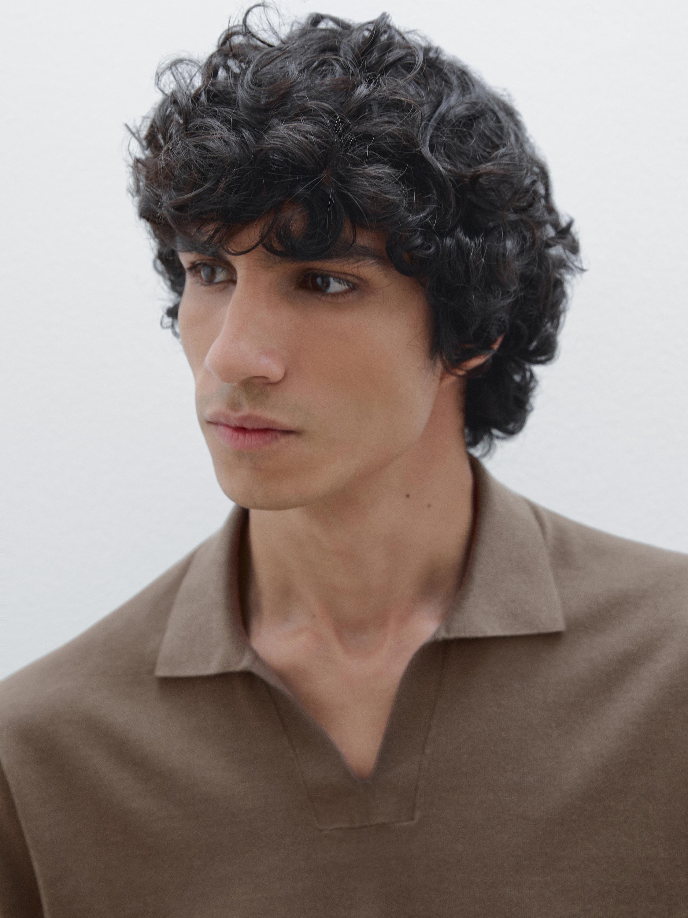 لقطة مقرّبة للرقبة والجزء العلوي من قميص بني