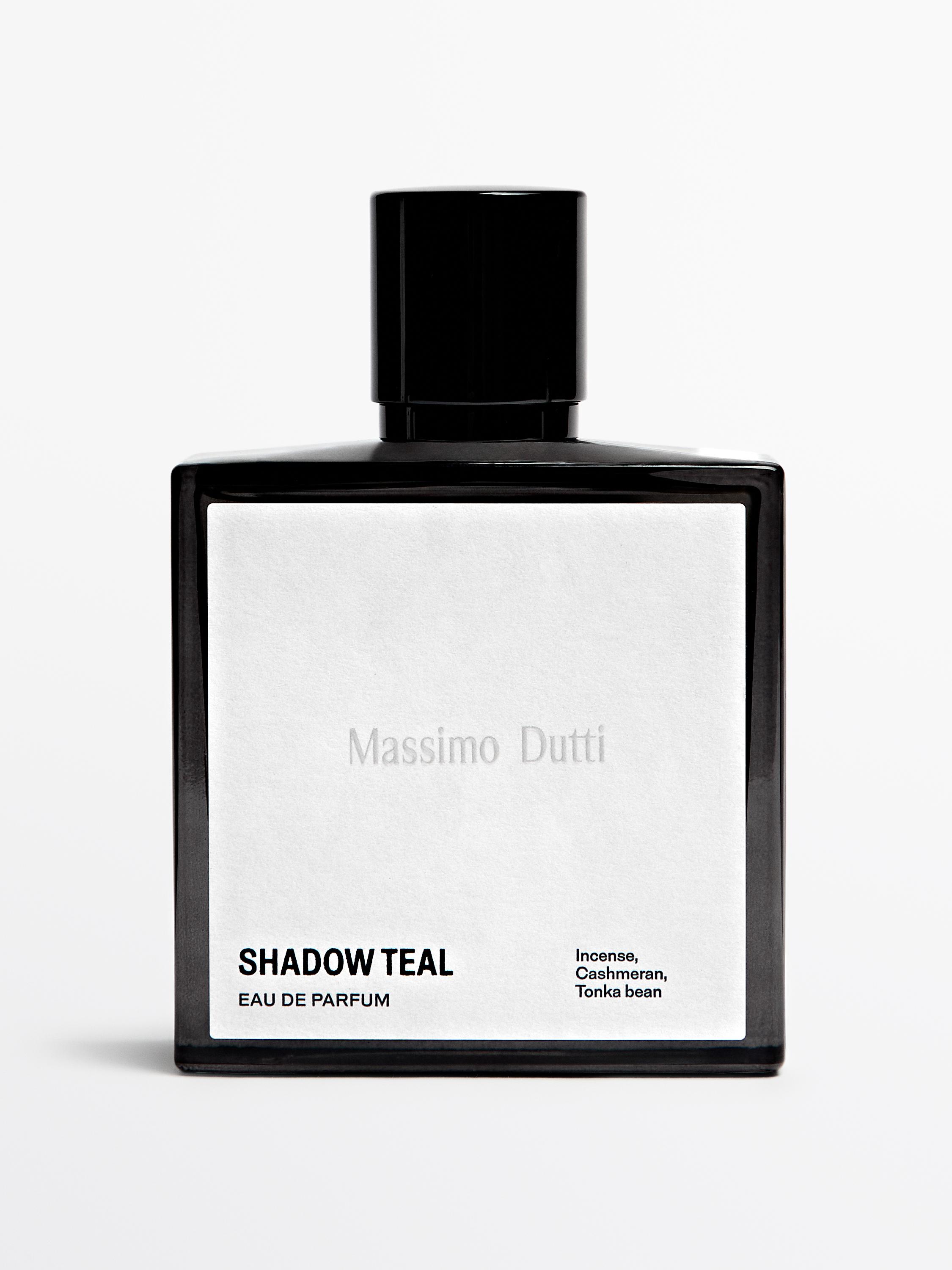 Botella de perfume negro con etiqueta blanca que dice "SHADOW TEAL EAU DE PARFUM" y "Inocencia, Cashmeran, Haba tonka".