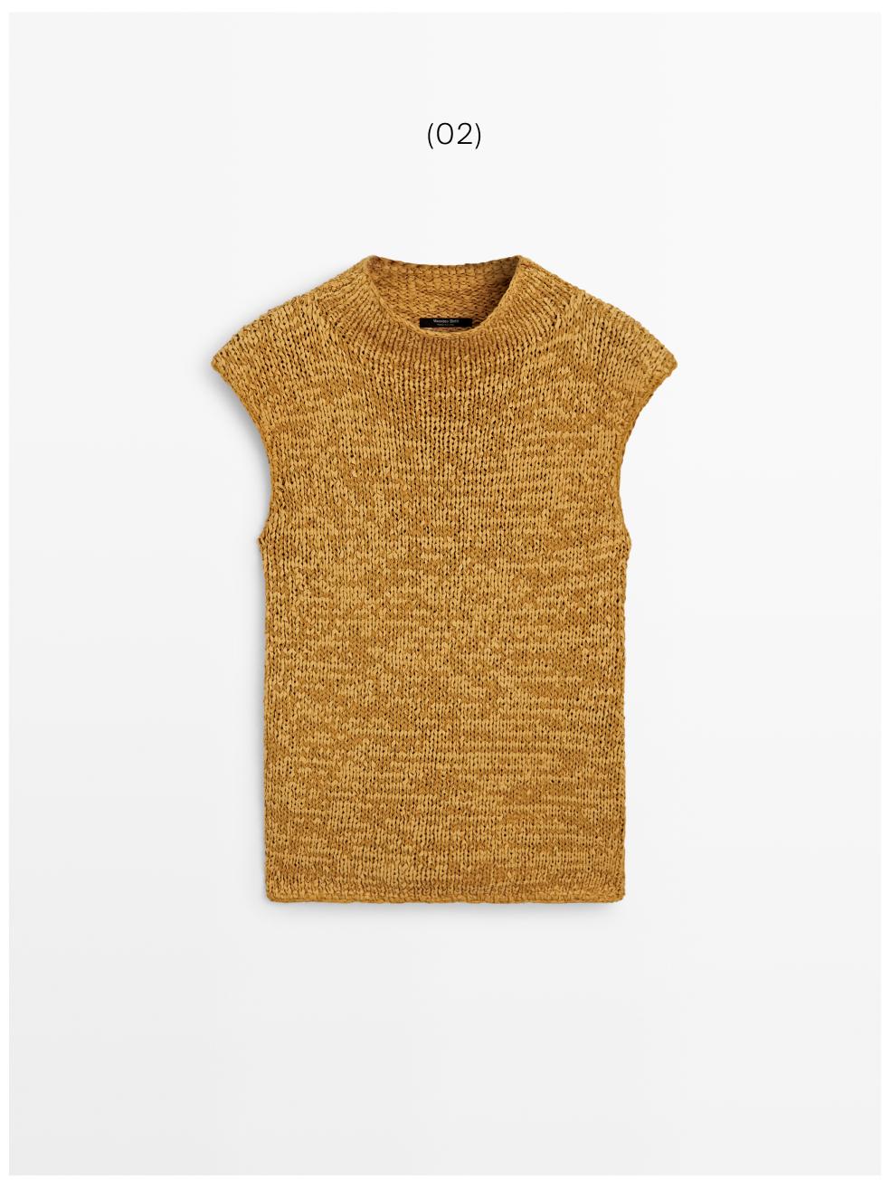 Μπροστινή όψη πλεκτού τοπ σε χρώμα κάρι με χοντρή πλέξη, στρογγυλή λαιμόκοψη και μανίκι ρεγκλάν, με μελανζέ φινίρισμα.