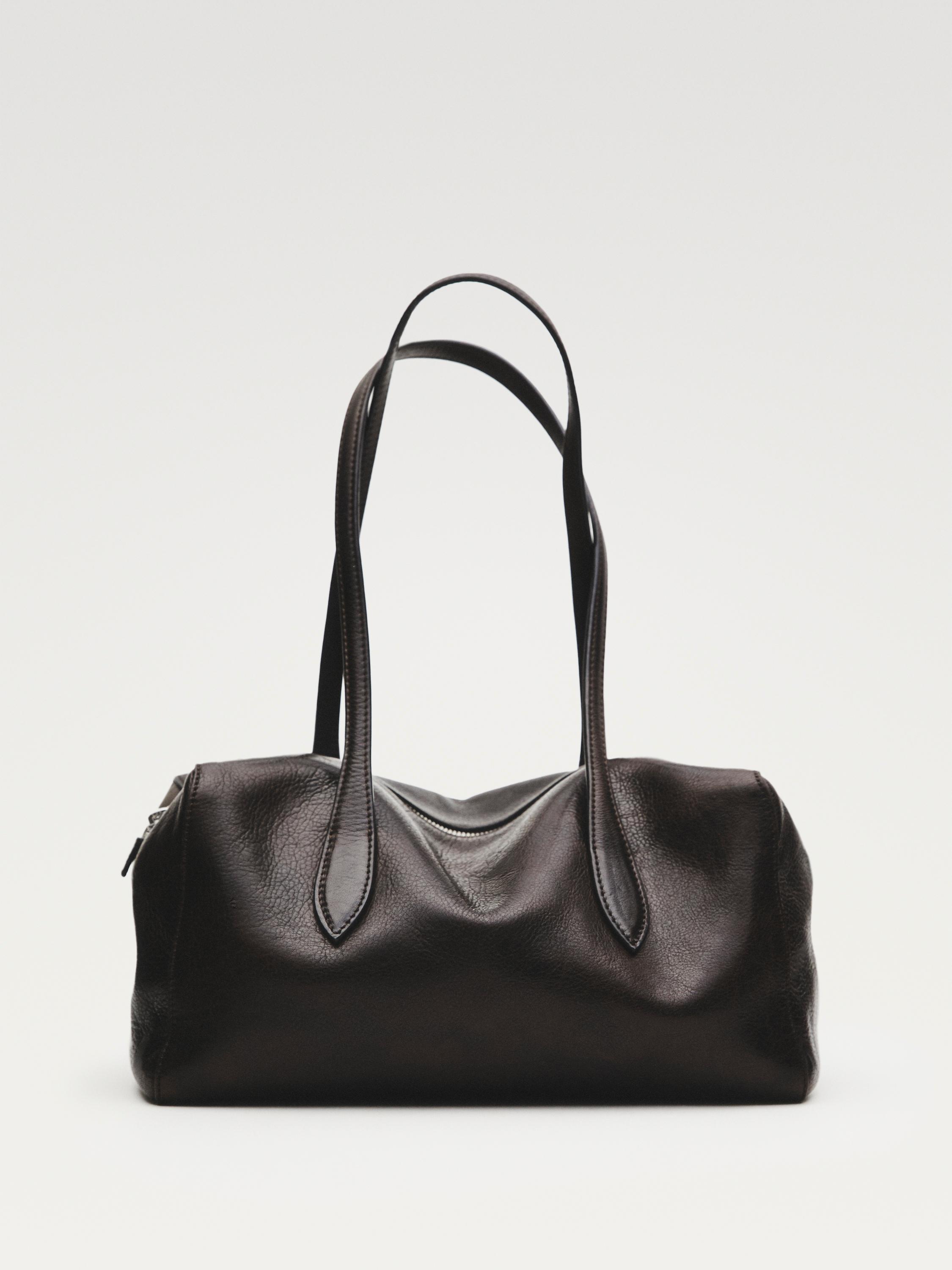 Front view of a brown handbag with long handles and a top zipper closure. Dimensions: 40 x 17 x 13 cm.