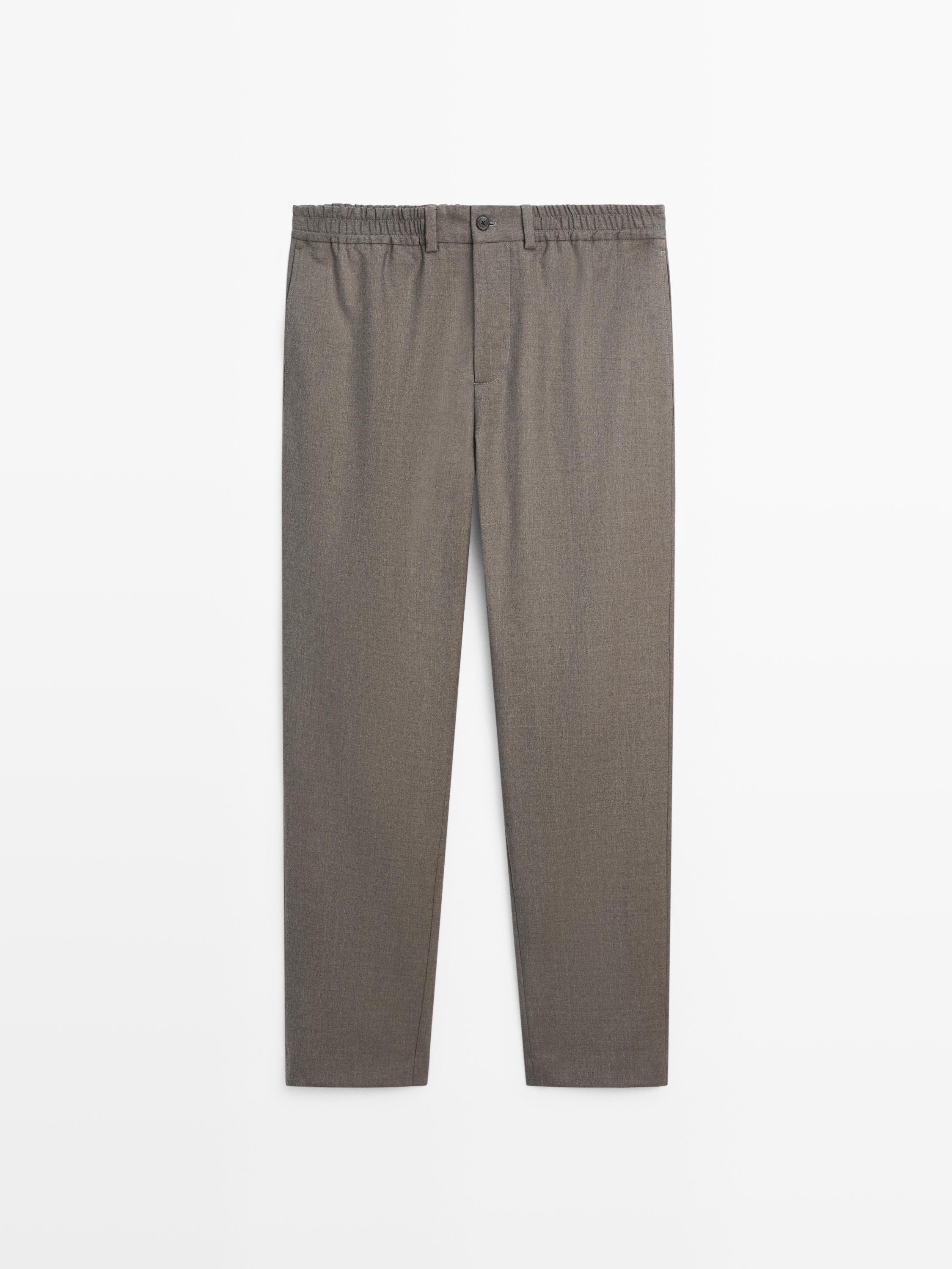 Front view of medium raw pants with elastic waist and front button.