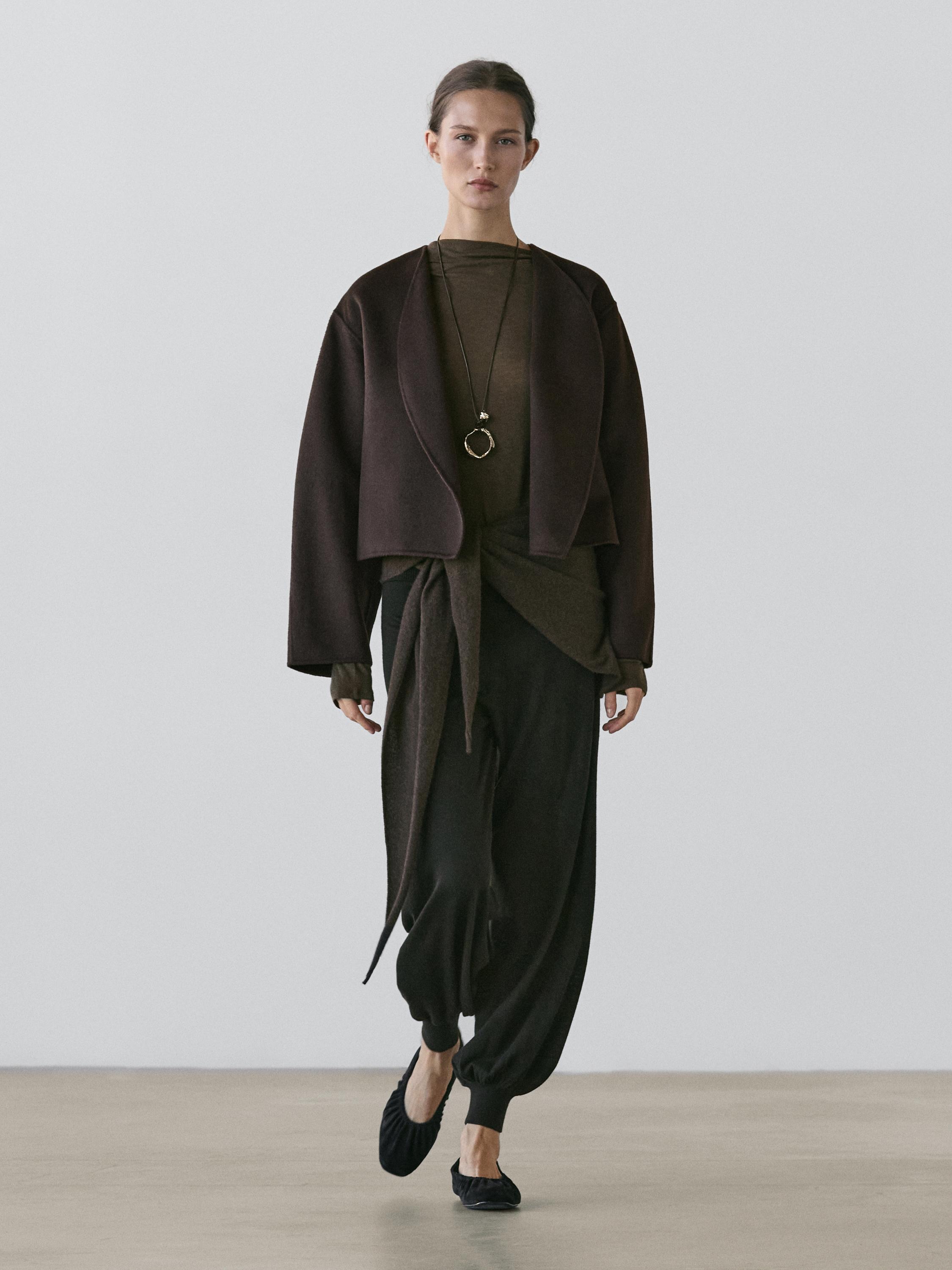 Chocolate short coat set with rounded lapels, dark loose pants, and black shoes.