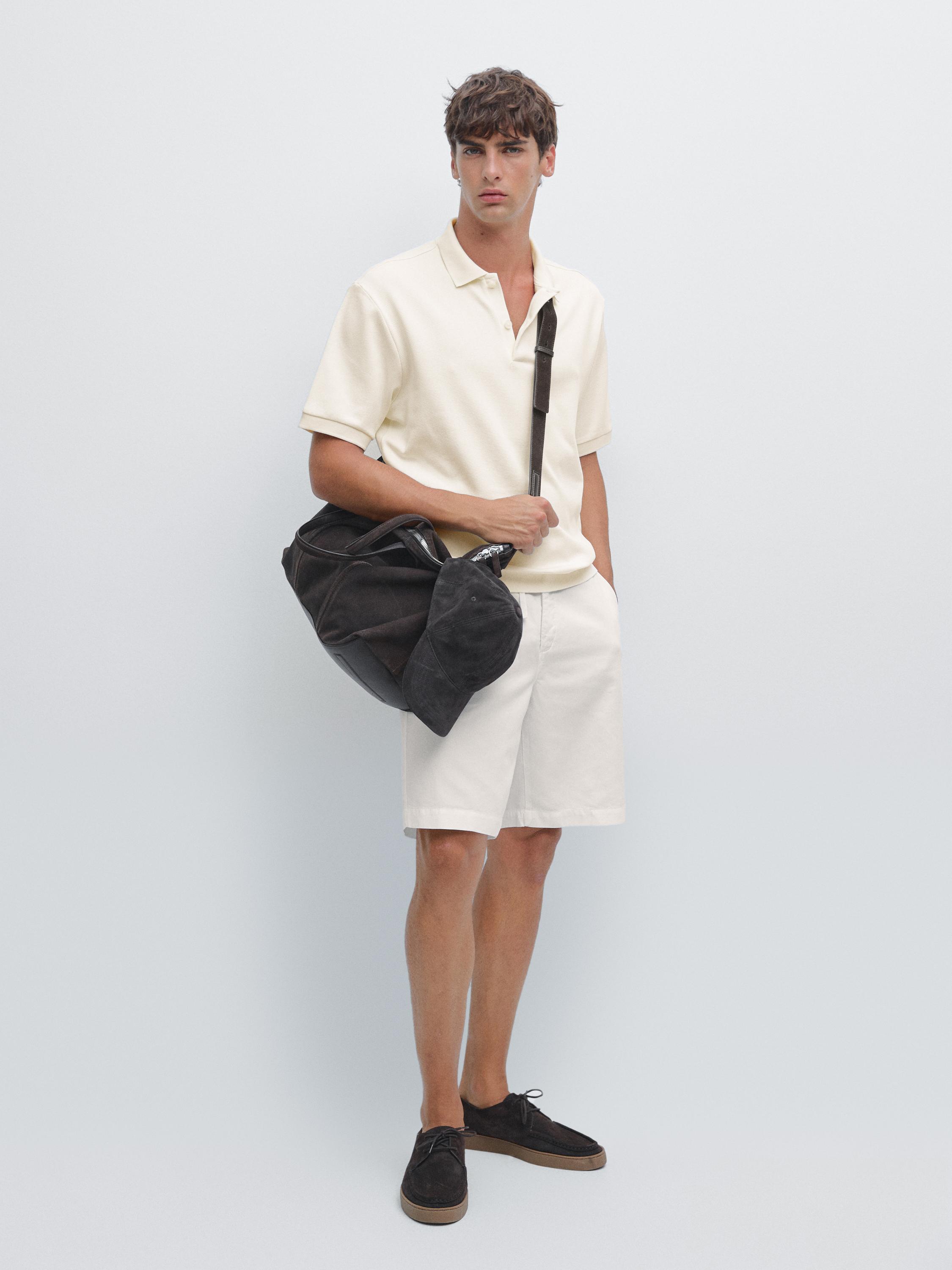 Ensemble polo crème à manches courtes avec col ouvert et shorts blancs.