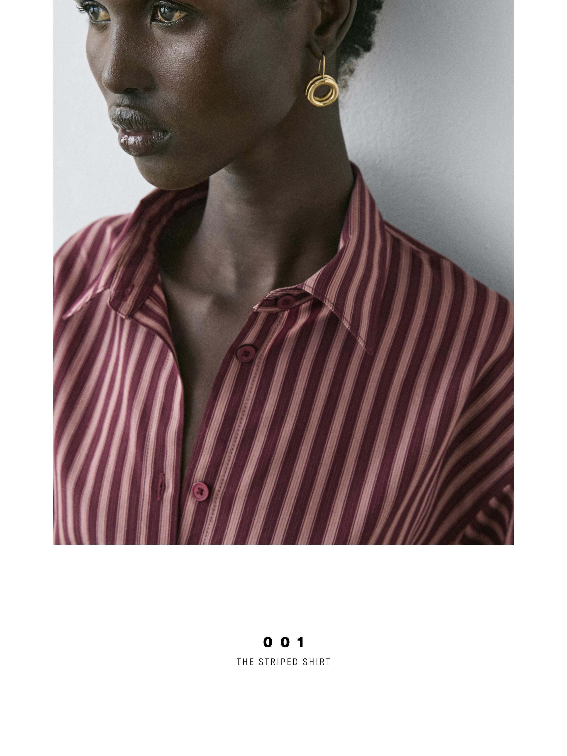 "Halbnahe Aufnahme eines braunen Hemdes mit vertikalen Streifen und sichtbarer Knopfleiste."