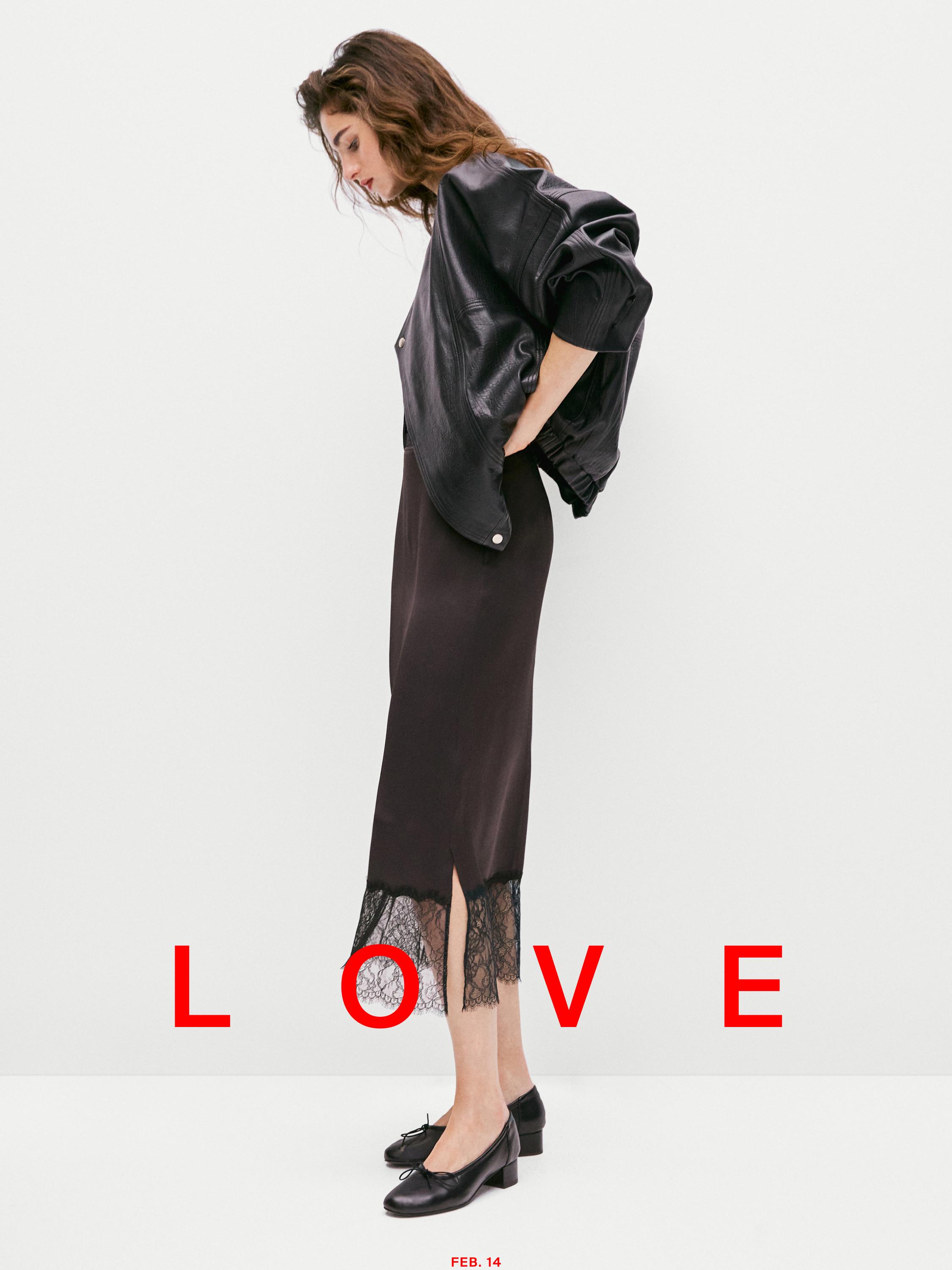 Set bestaande uit een zwarte jas, een zwarte rok met kant aan de zoom en rode tekst "LOVE".