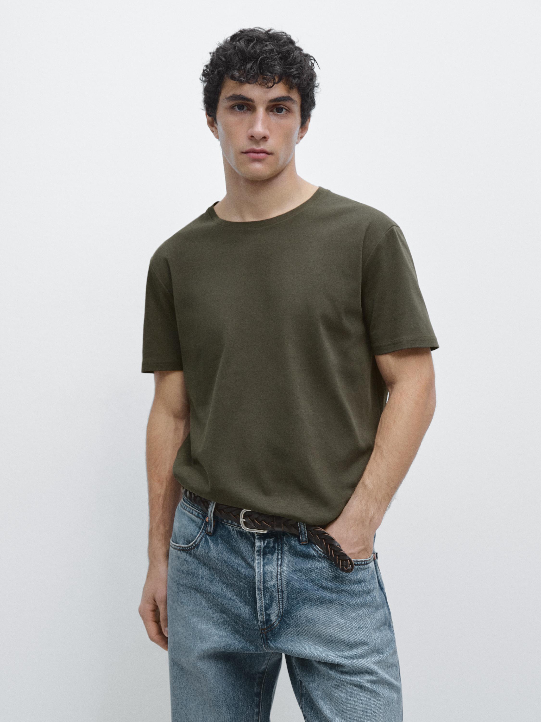 Ensemble composé d'un t-shirt kaki à manches courtes et d'un jean bleu.