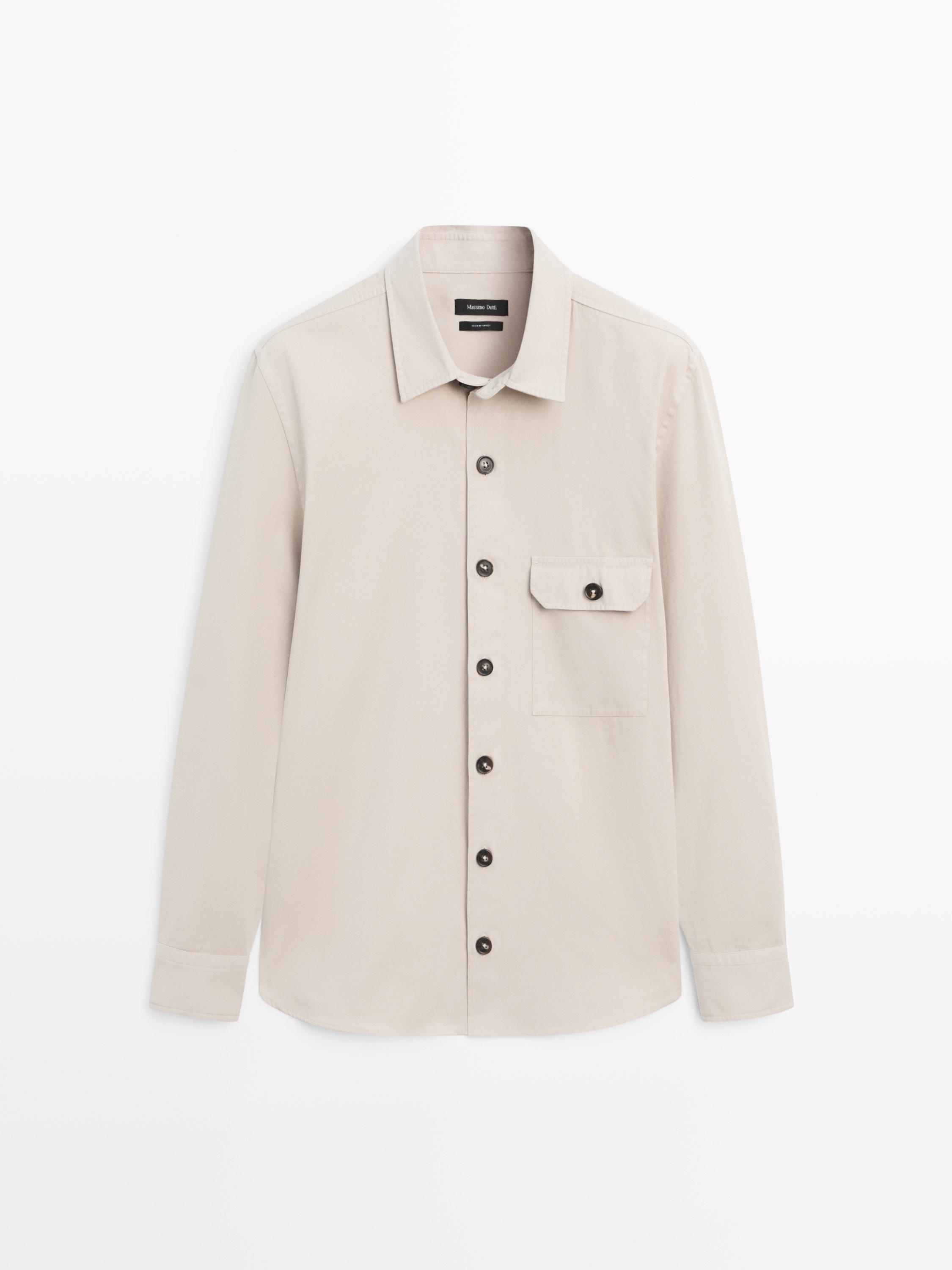 Vista frontale di una sopracamicia beige a maniche lunghe con bottoni scuri e tasca frontale con patta.