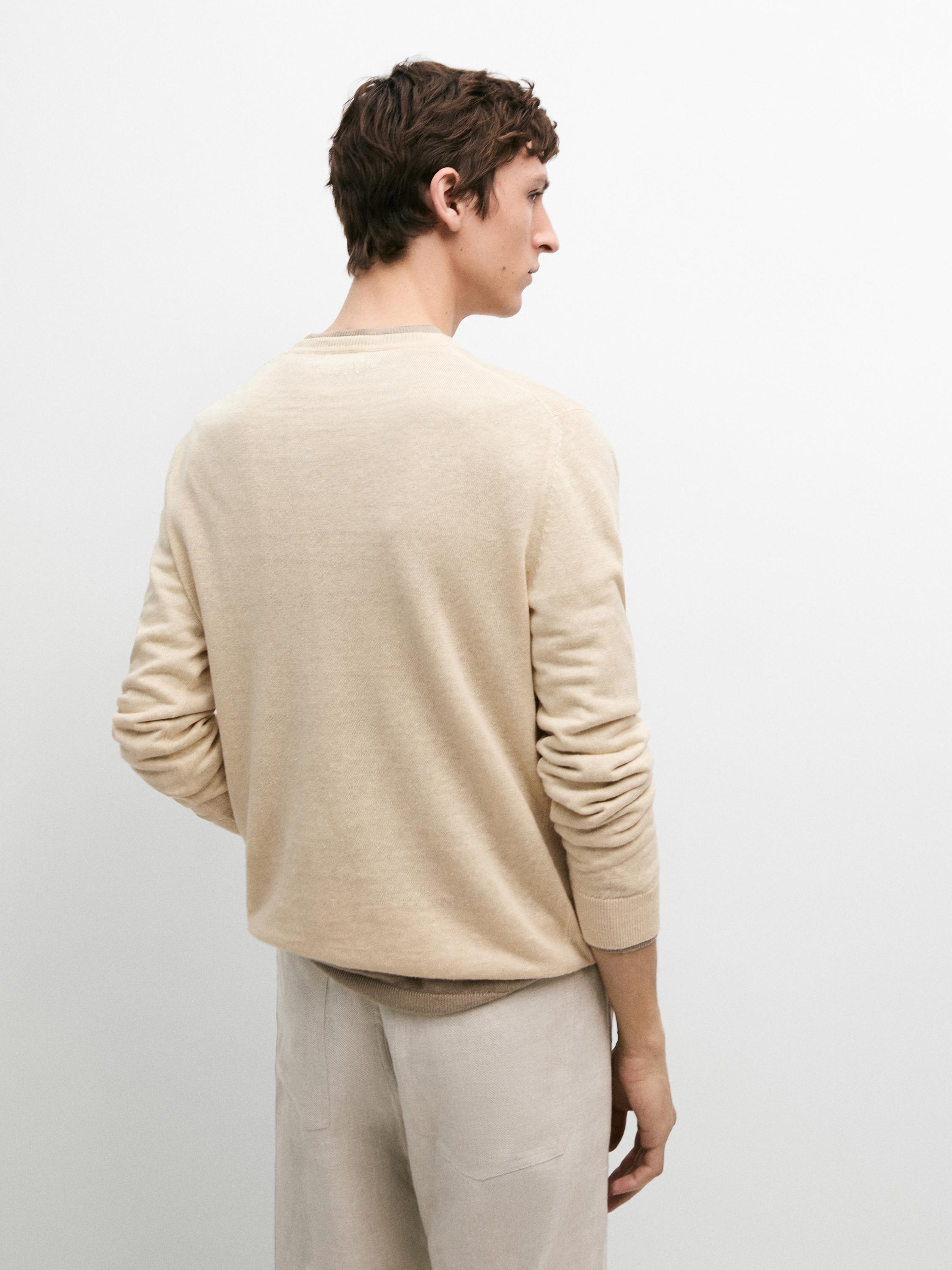 Conjunto de suéter vainilla de punto con cuello redondo y pantalón beige.