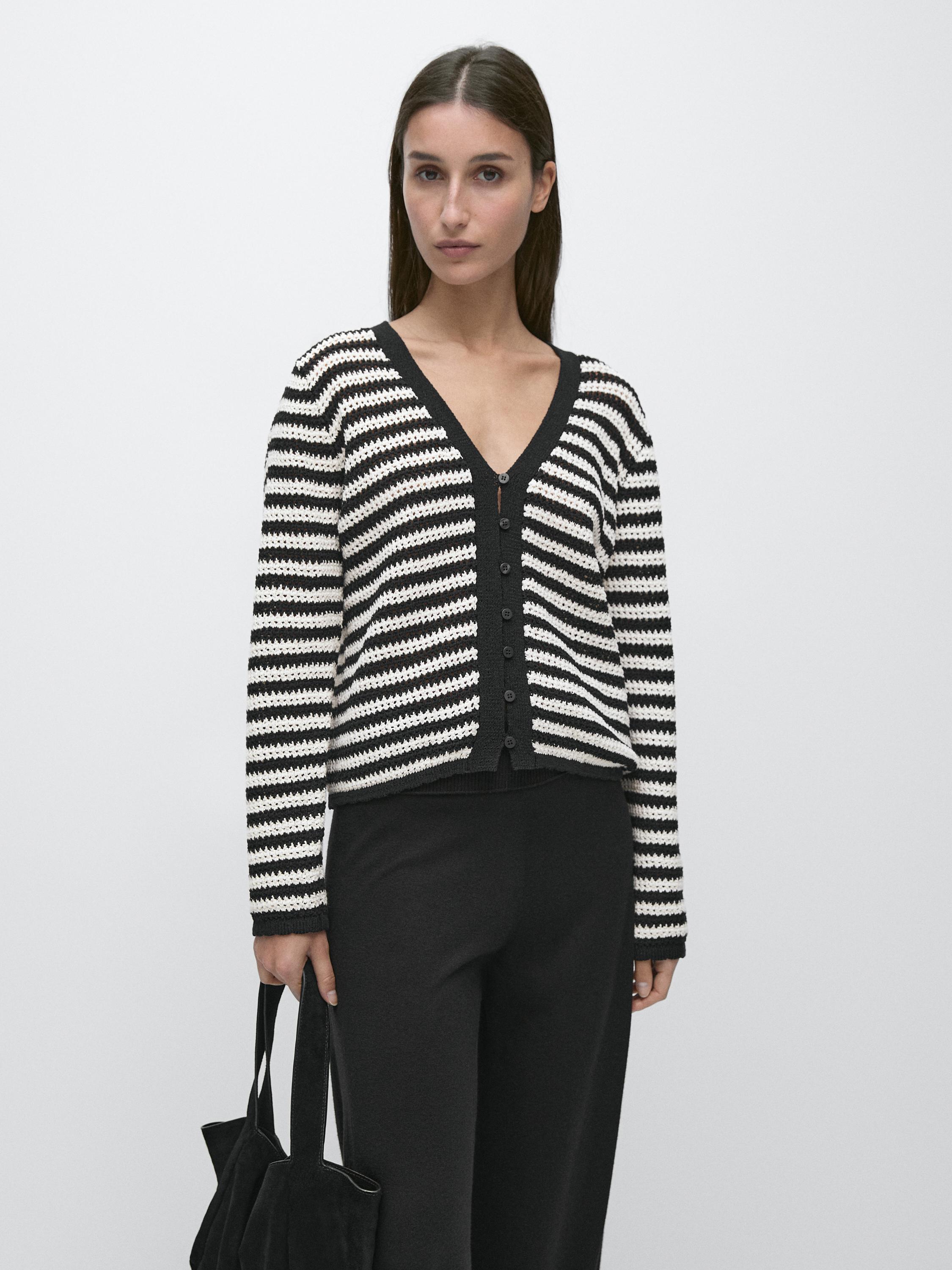 Black and white striped button-up cardigan set with black pants.