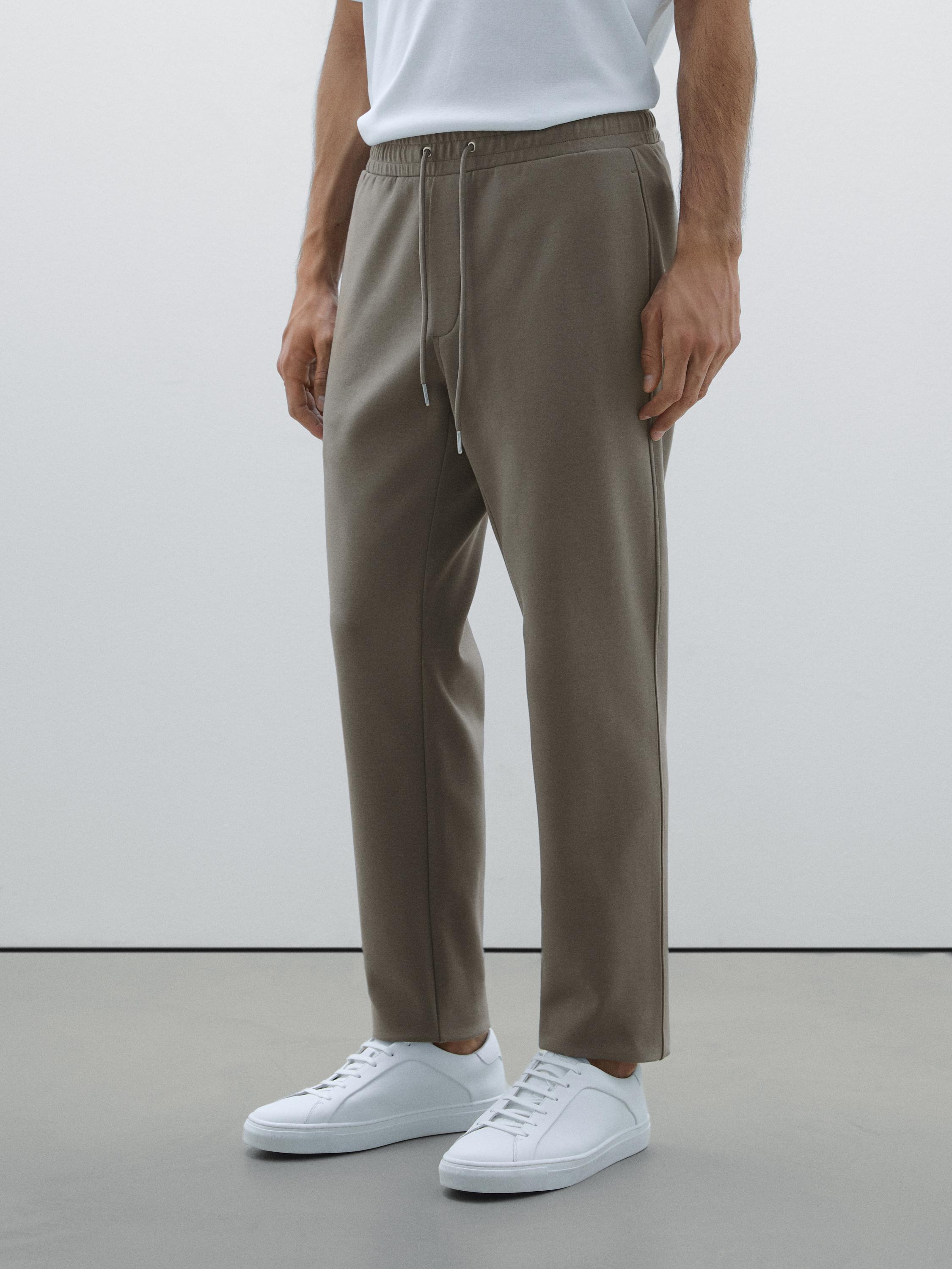 Ensemble T-shirt blanc et pantalon kaki avec taille élastique et poches latérales.