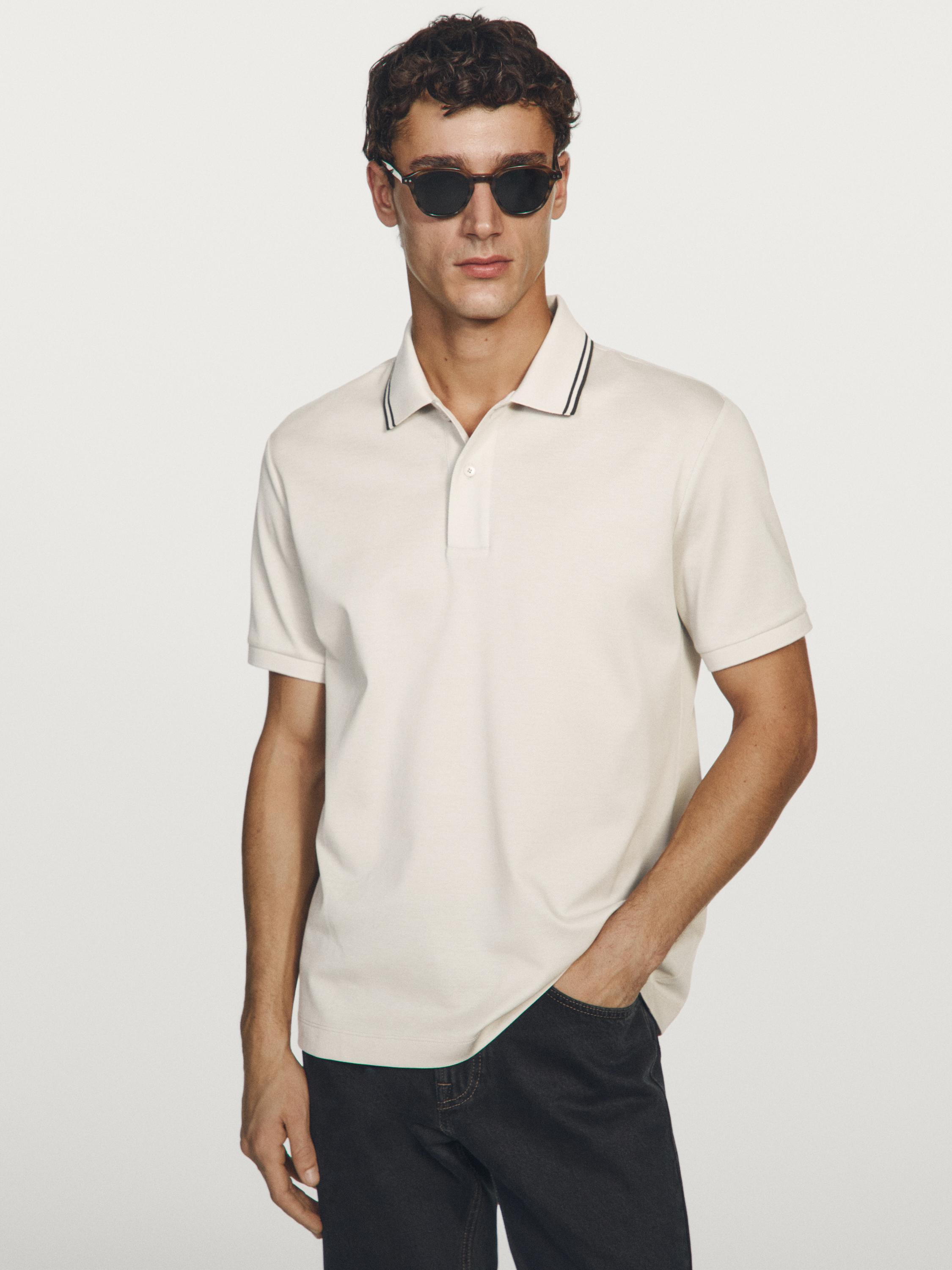 Ecru short-sleeve polo set with contrast detail on the collar and dark pants.