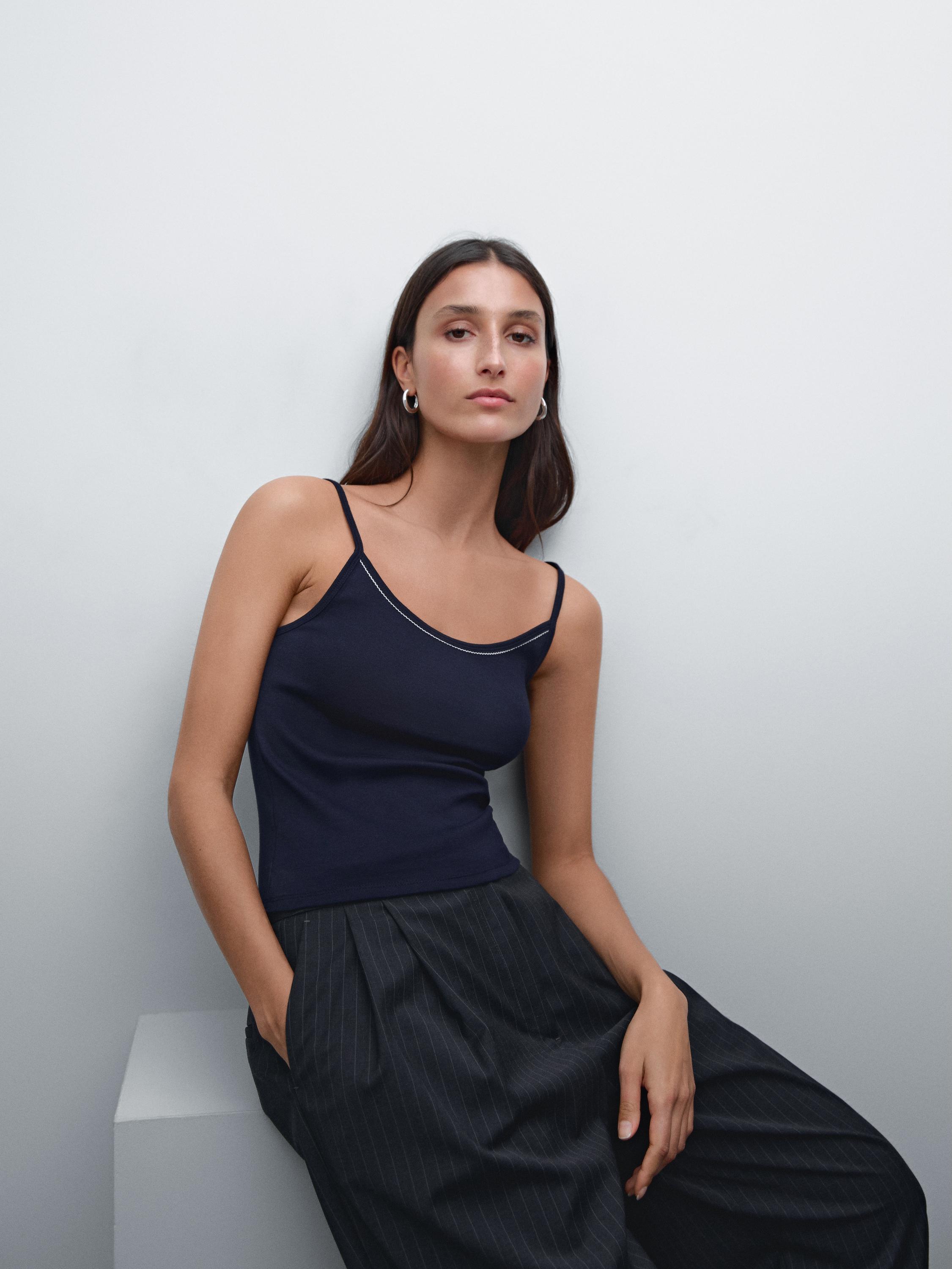 طقم يتكون من توب كحلي بحمالات رفيعة وبنطلون أسود واسع بجيوب جانبية.