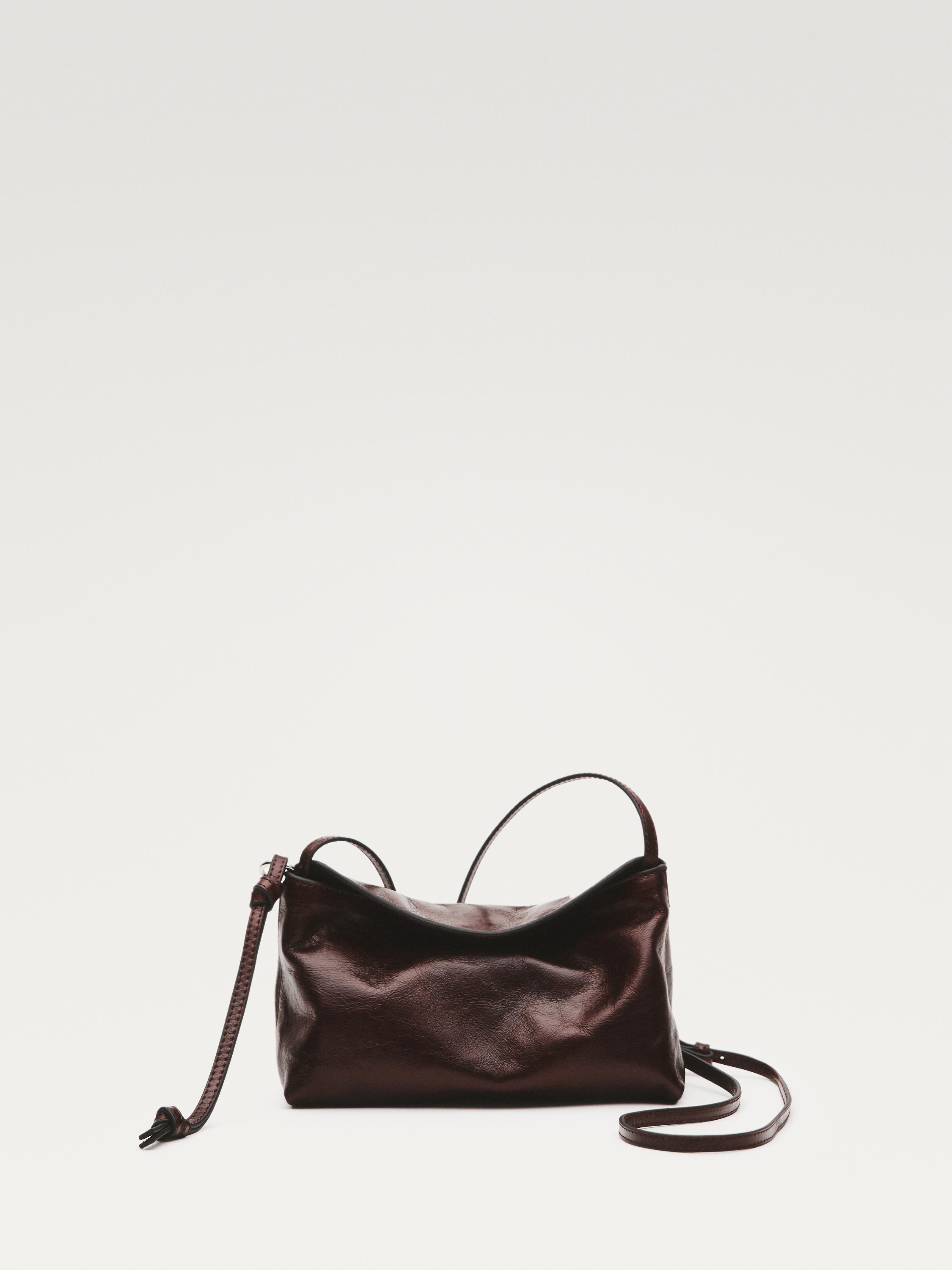 Vista frontal de moneder marró fosc amb tancament de cordó i corretja llarga ajustable.