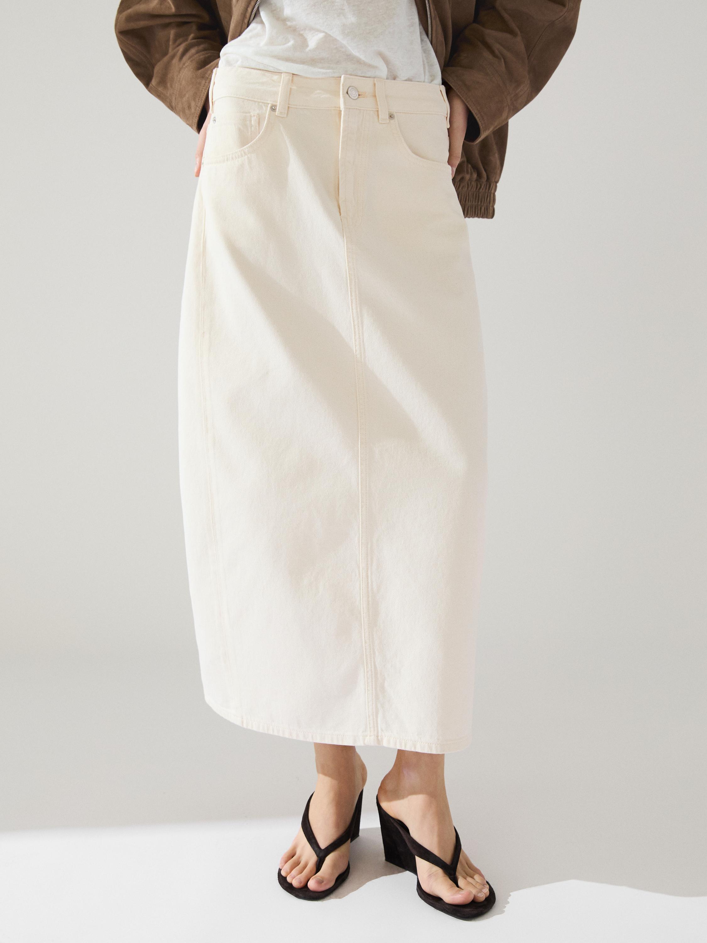 Beige long skirt set with front pockets and brown high-heeled sandals.
